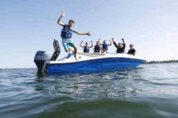 Group enjoying on a 2025 Starcraft SV 16 OB boat, with one person jumping into the water.