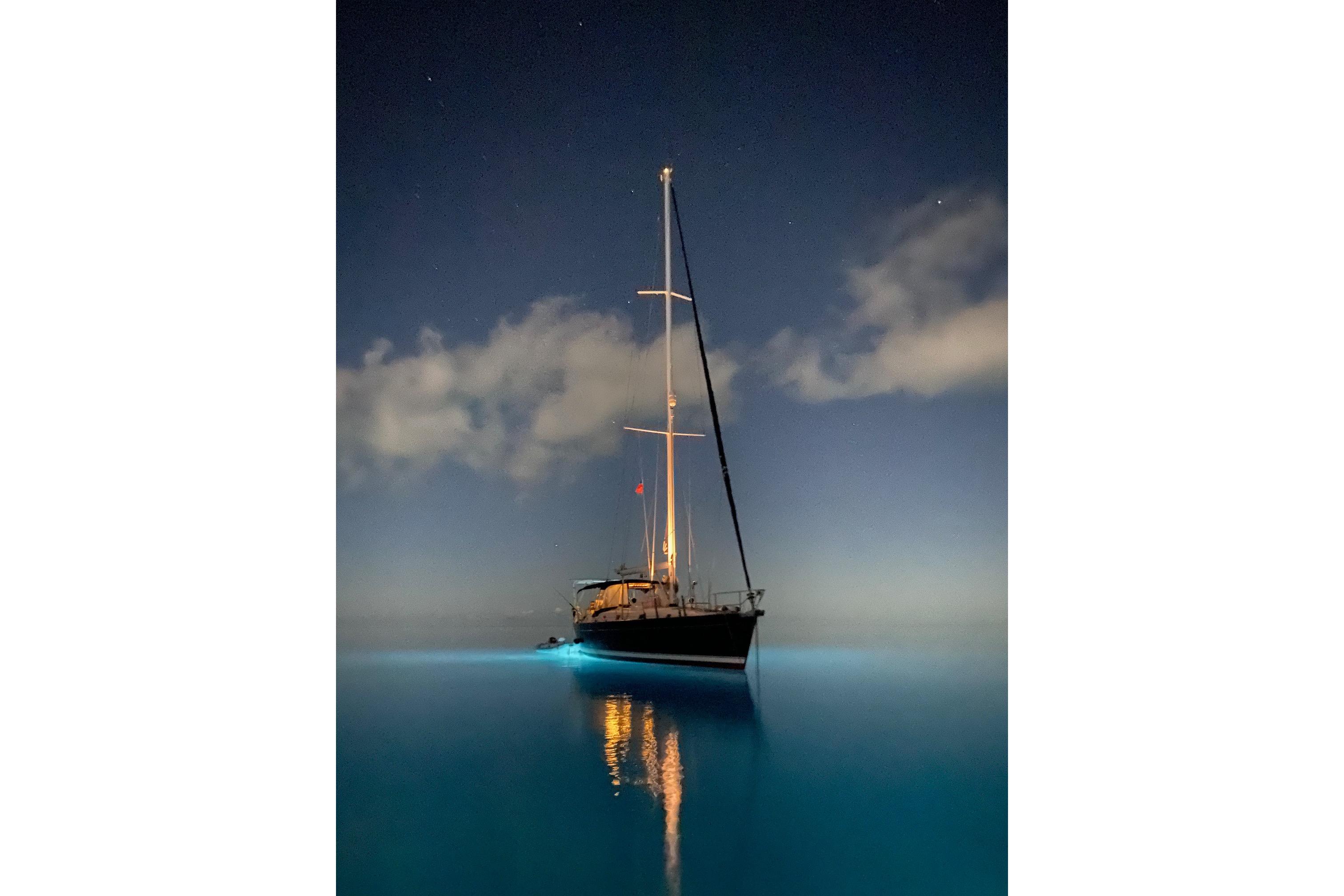 Sailboat Beneteau 50, 2004 model, illuminated on calm night sea.