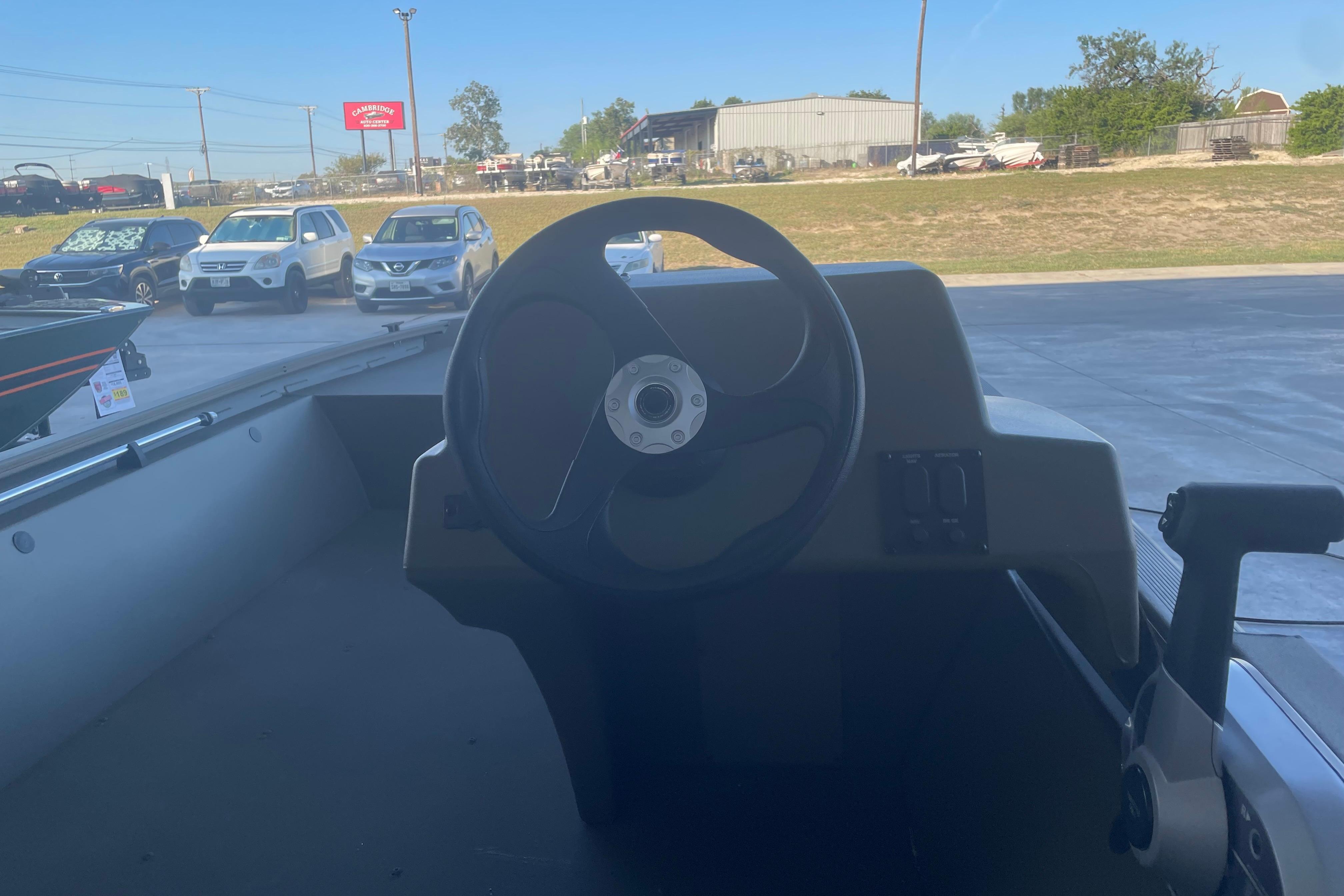 2026 Tracker Grizzly 1648 SC boat steering console in outdoor dealership setting.
