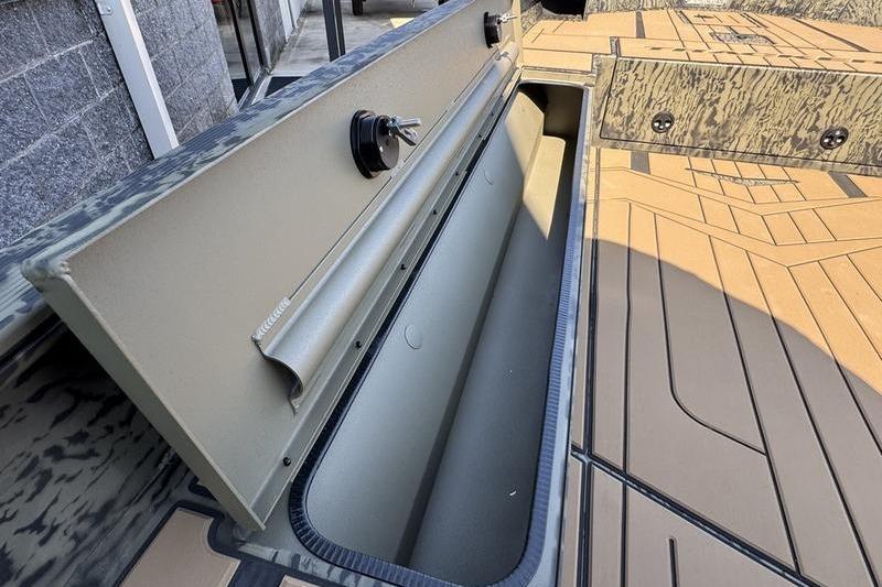 2026 Tracker Grizzly 1756 T Marsh boat storage compartment, open lid, camo design.