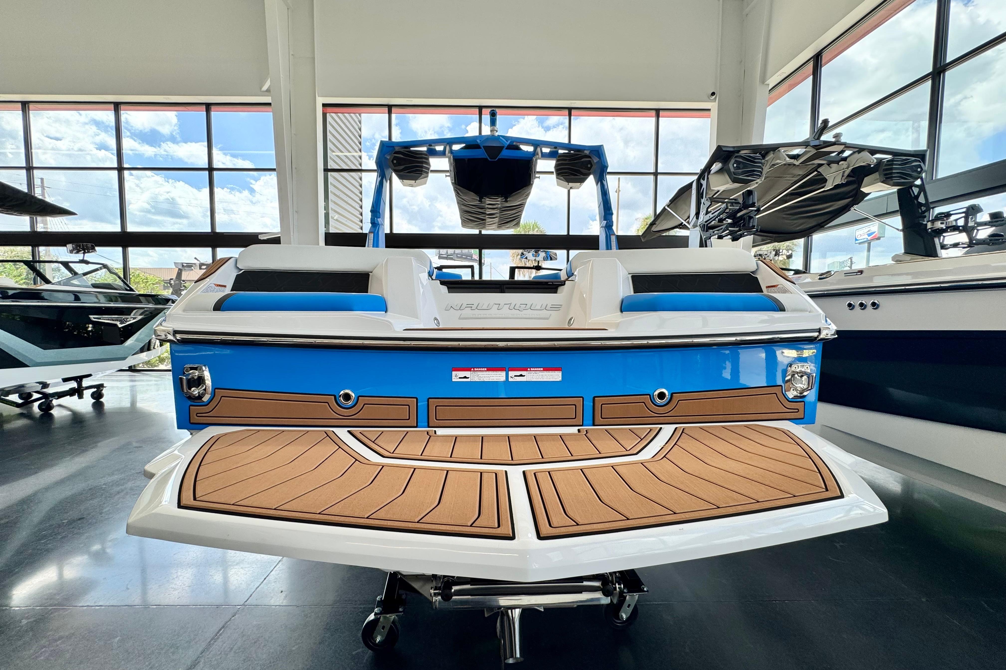 2026 Nautique Super Air Nautique GS22 in showroom, rear view, blue and white design.