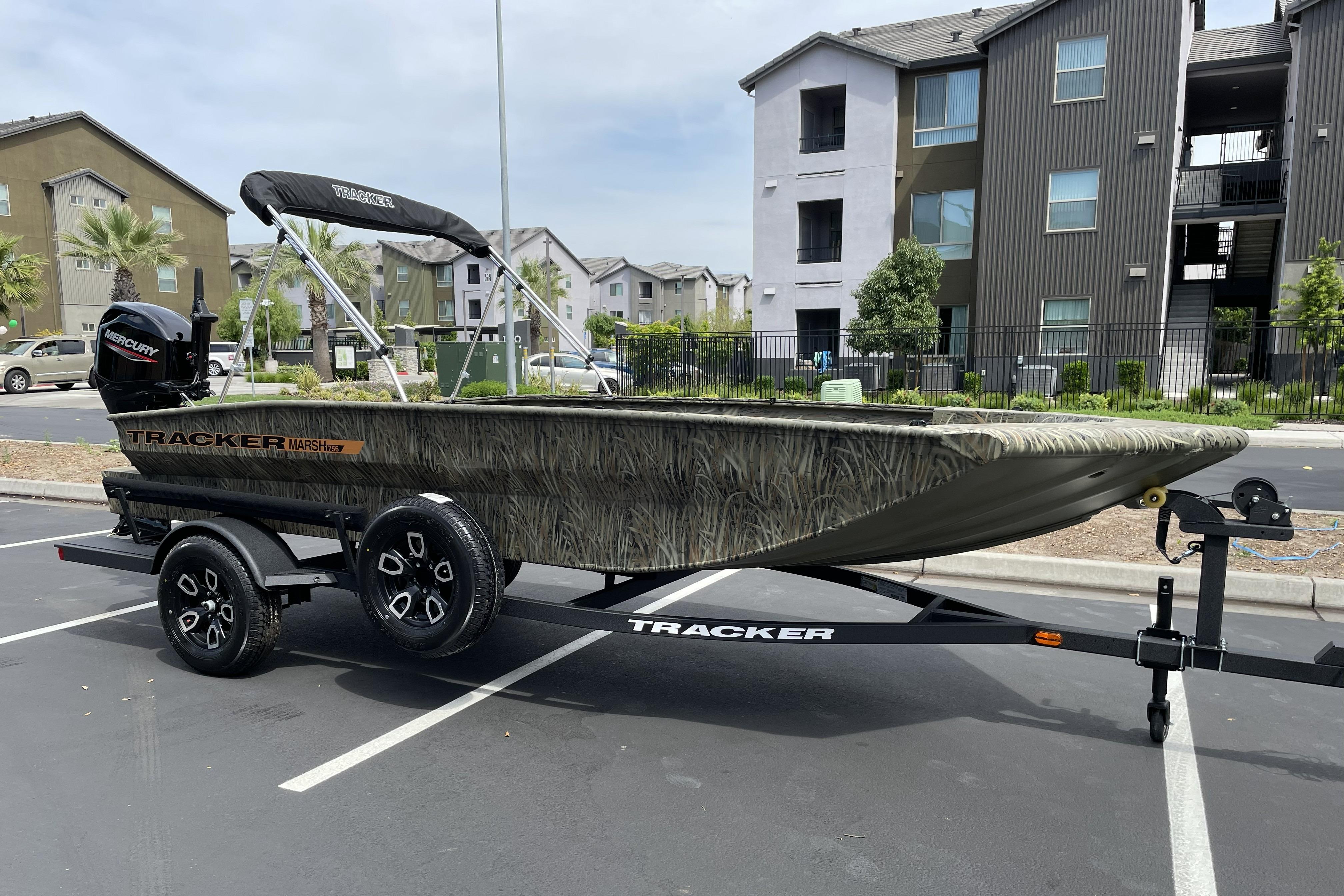 2026 Tracker Grizzly 1756 T Marsh boat on trailer, parked in urban setting.