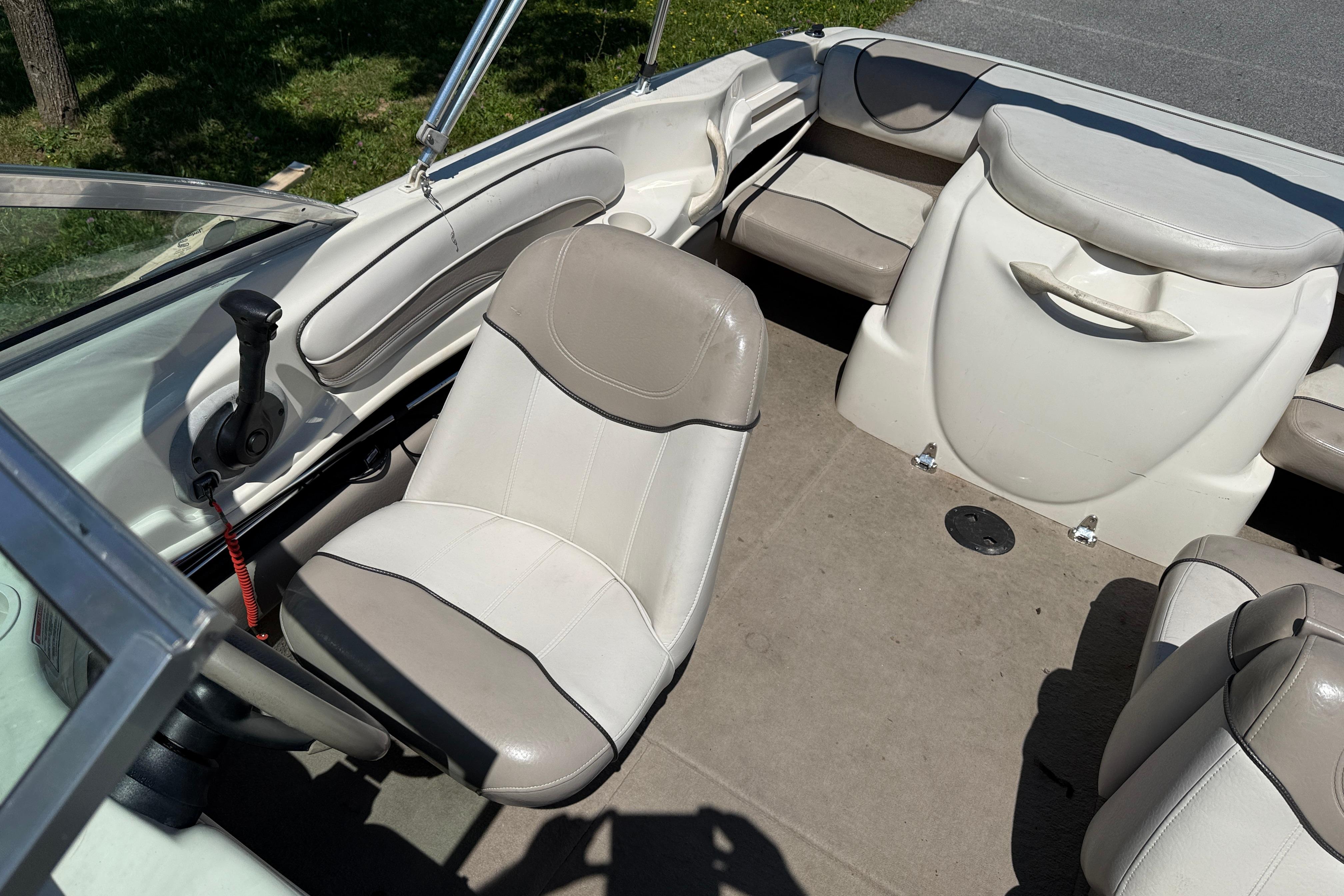 2003 Sea Ray 182 Bow Rider interior with beige seating and steering wheel.