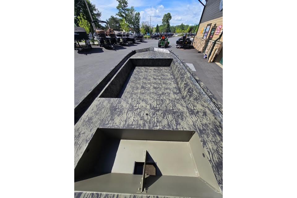2026 Tracker Grizzly 1860 Utility boat with camouflage design on display outdoors.