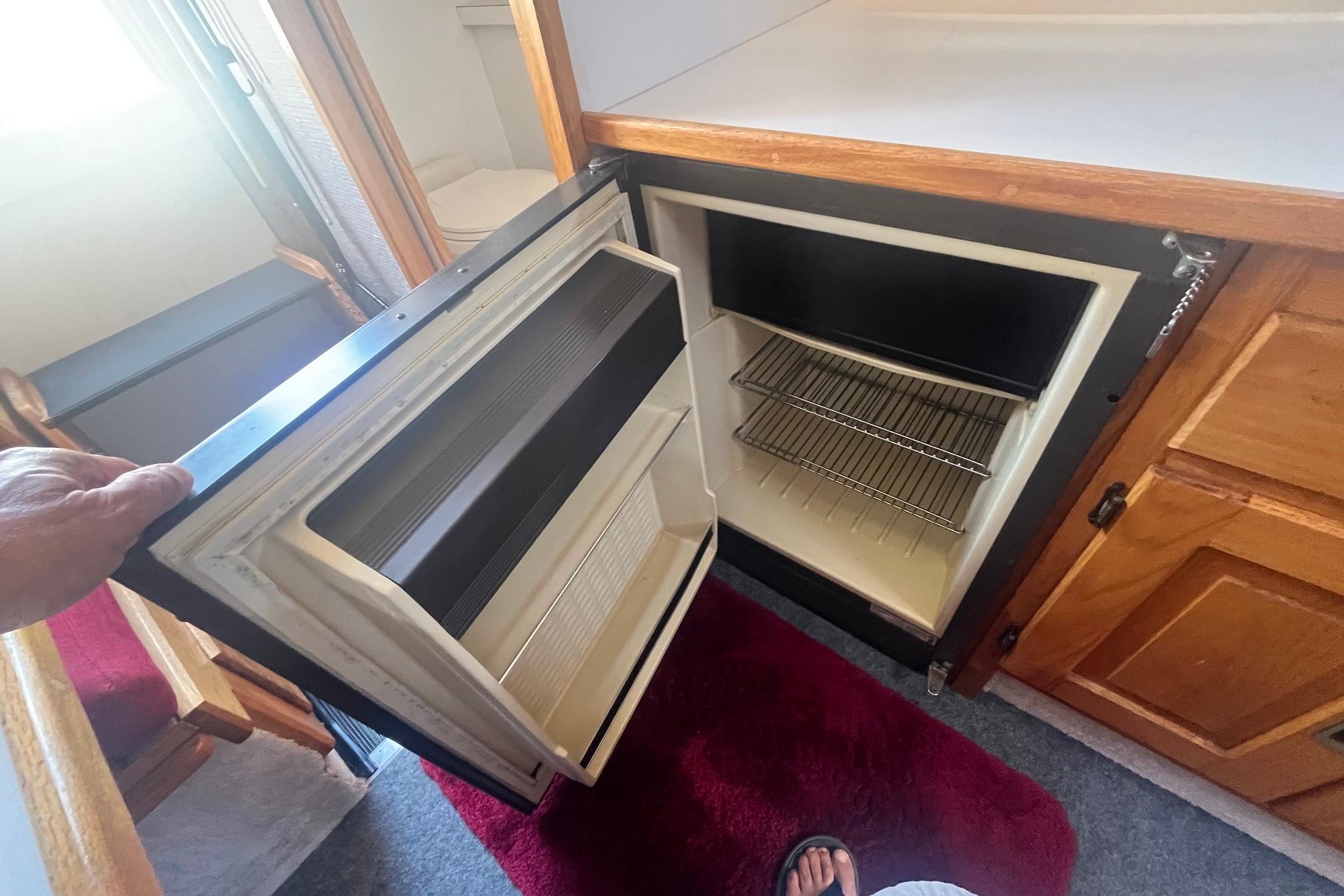 Open refrigerator inside 1988 Seafox 29 Flybridge boat, showing interior shelves.