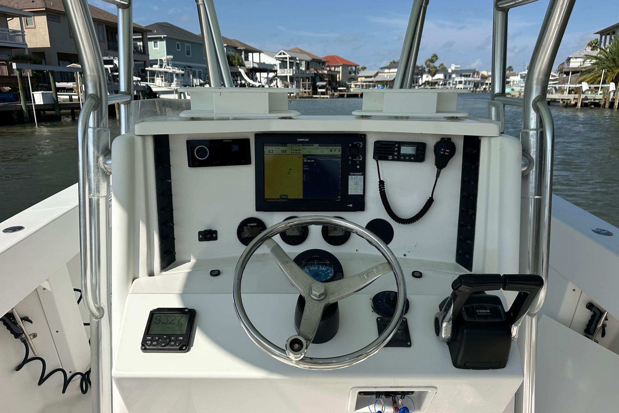 2003 Venture 34 Center Console boat dashboard with navigation equipment and steering wheel.
