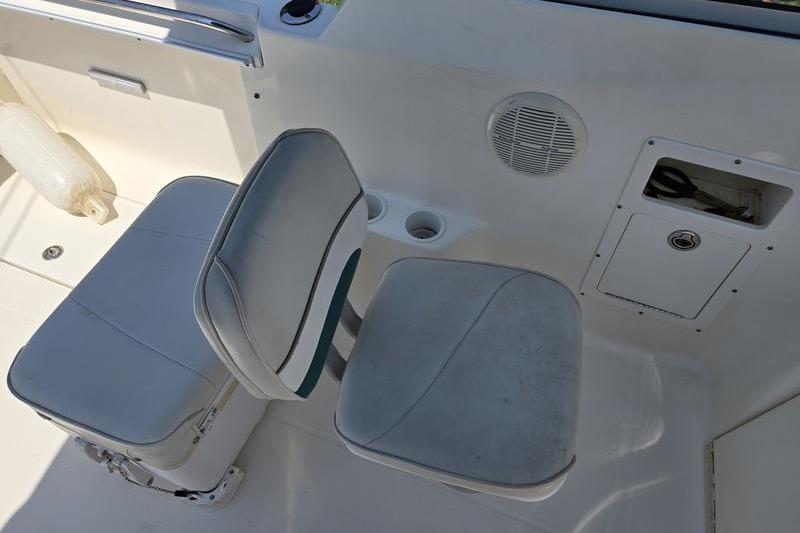 Two cushioned seats on a 2004 Aquasport 215 Osprey Sport boat interior.