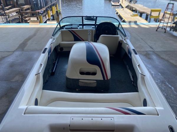 1998 Malibu Response boat interior with striped upholstery, docked by the water.