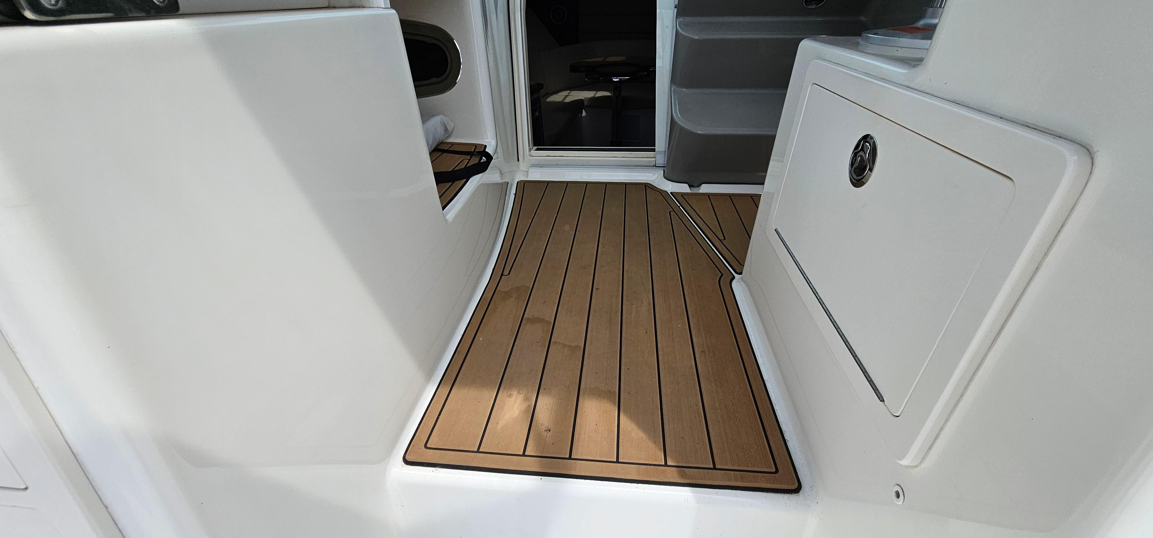 2016 Boston Whaler 285 Conquest interior with teak flooring and storage compartment.