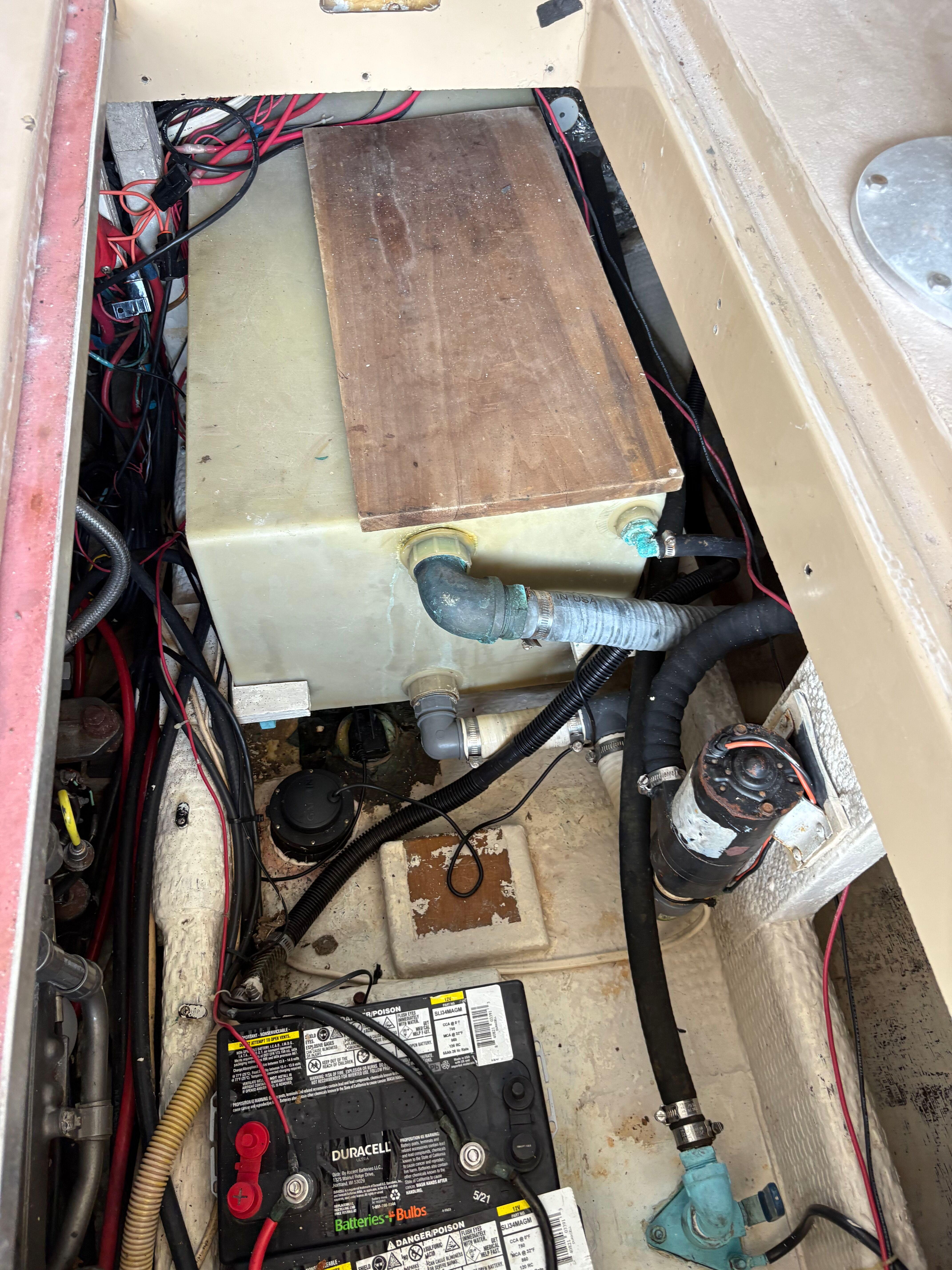 1988 Ellis Down East boat engine compartment with battery, wiring, and hoses.