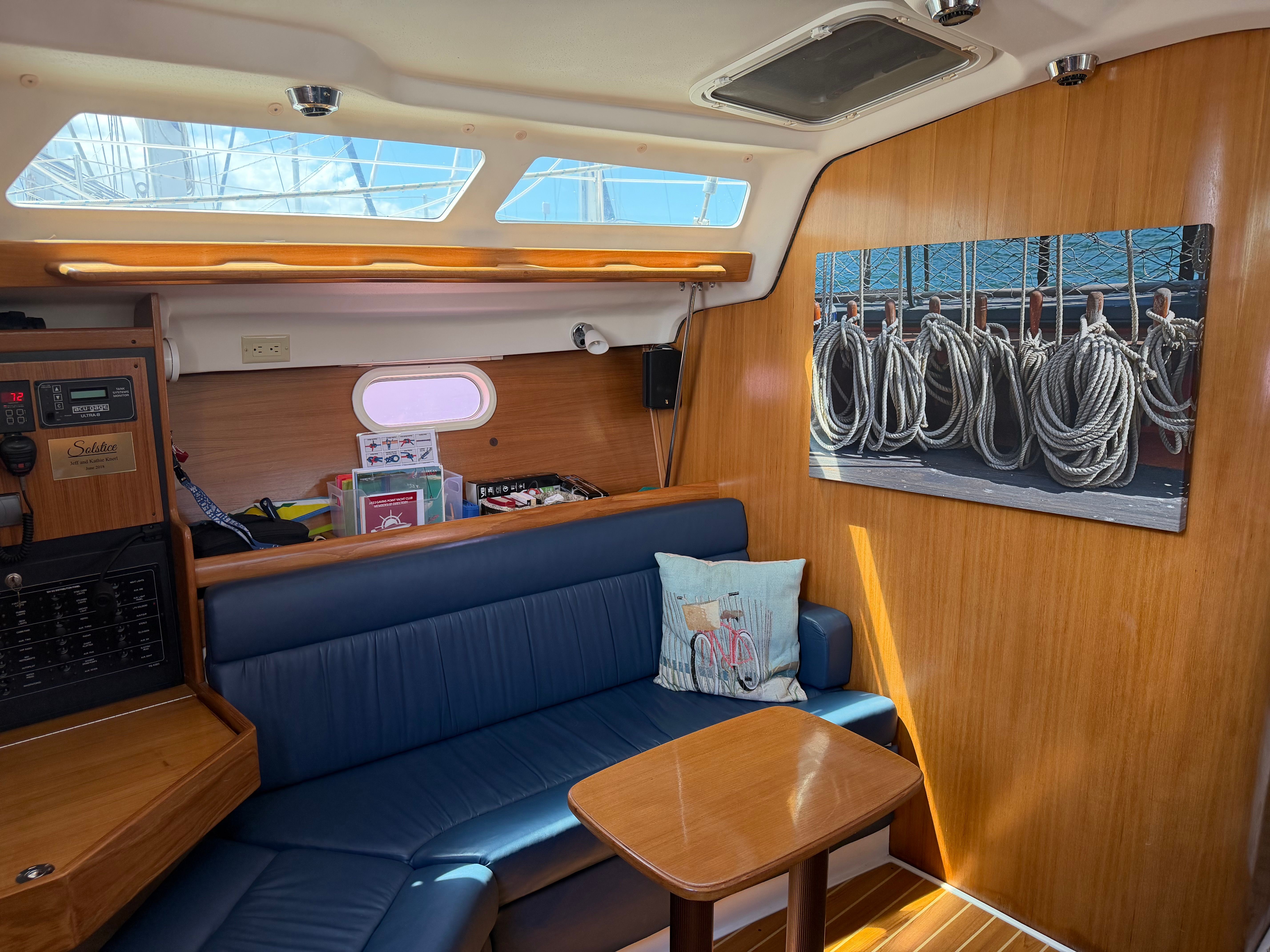 Interior of a Catalina 350 with blue seating and wooden table.