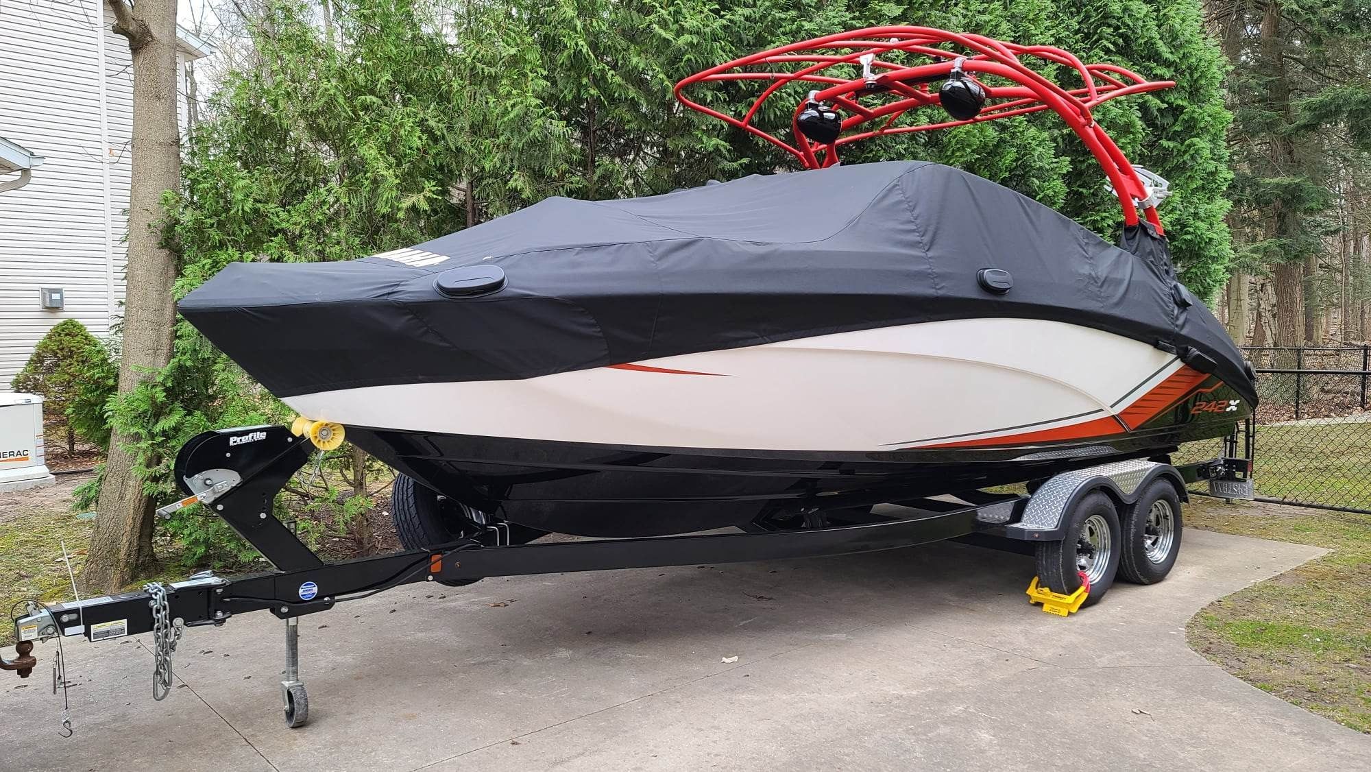 A 2018 Yamaha 242X E-Series boat on a trailer, covered and ready for transport.