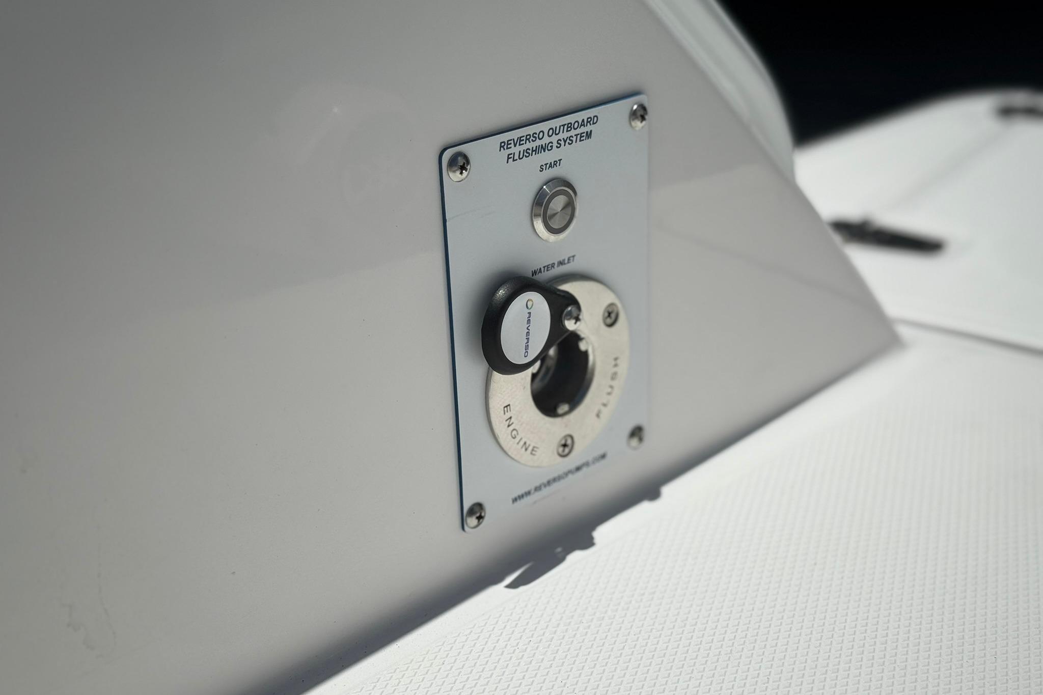 2026 Edgewater 250CC boat's outboard flushing system detail, featuring water inlet and start button.