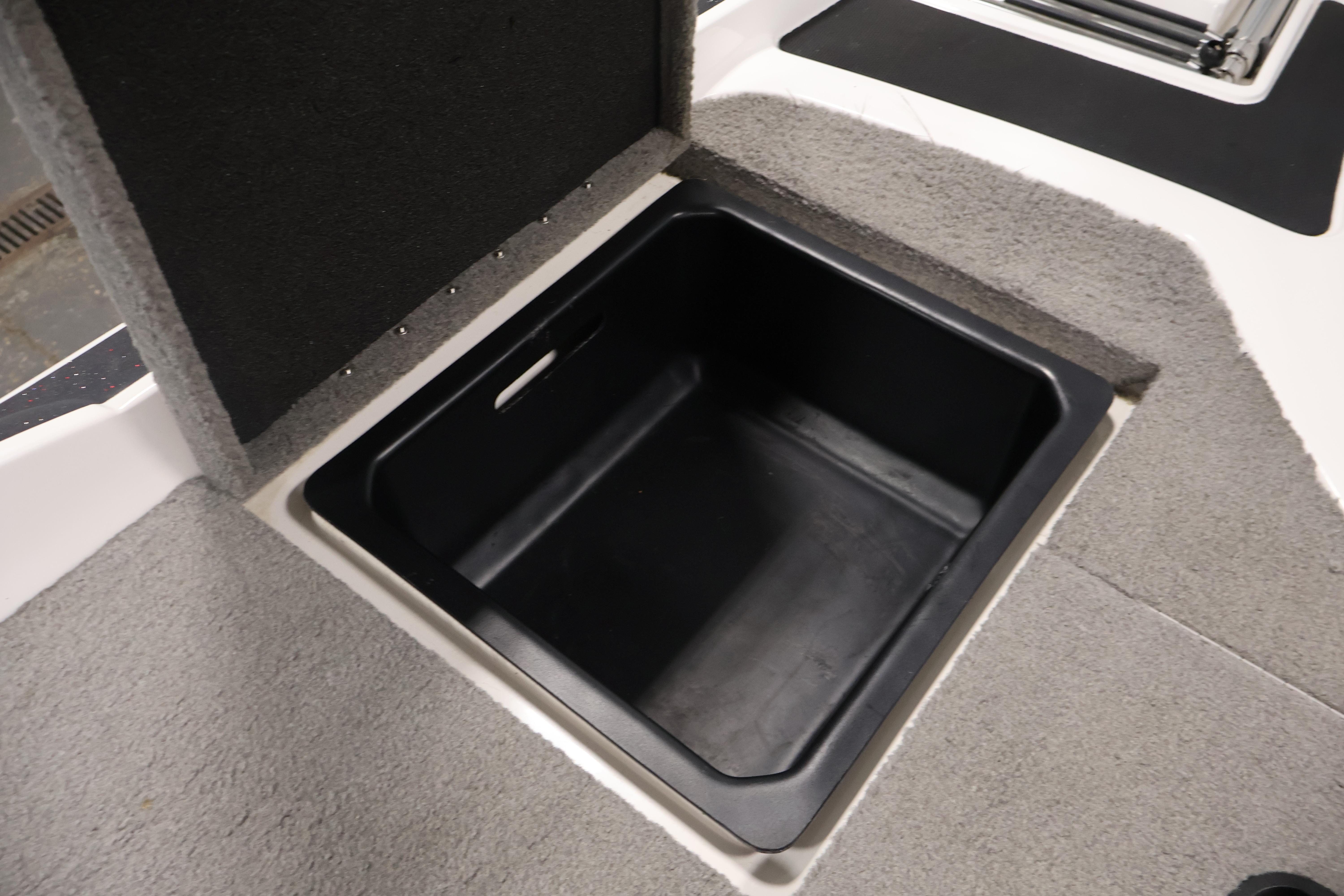 Open storage compartment in 2019 Nitro Z19 Sport boat, featuring carpeted interior.
