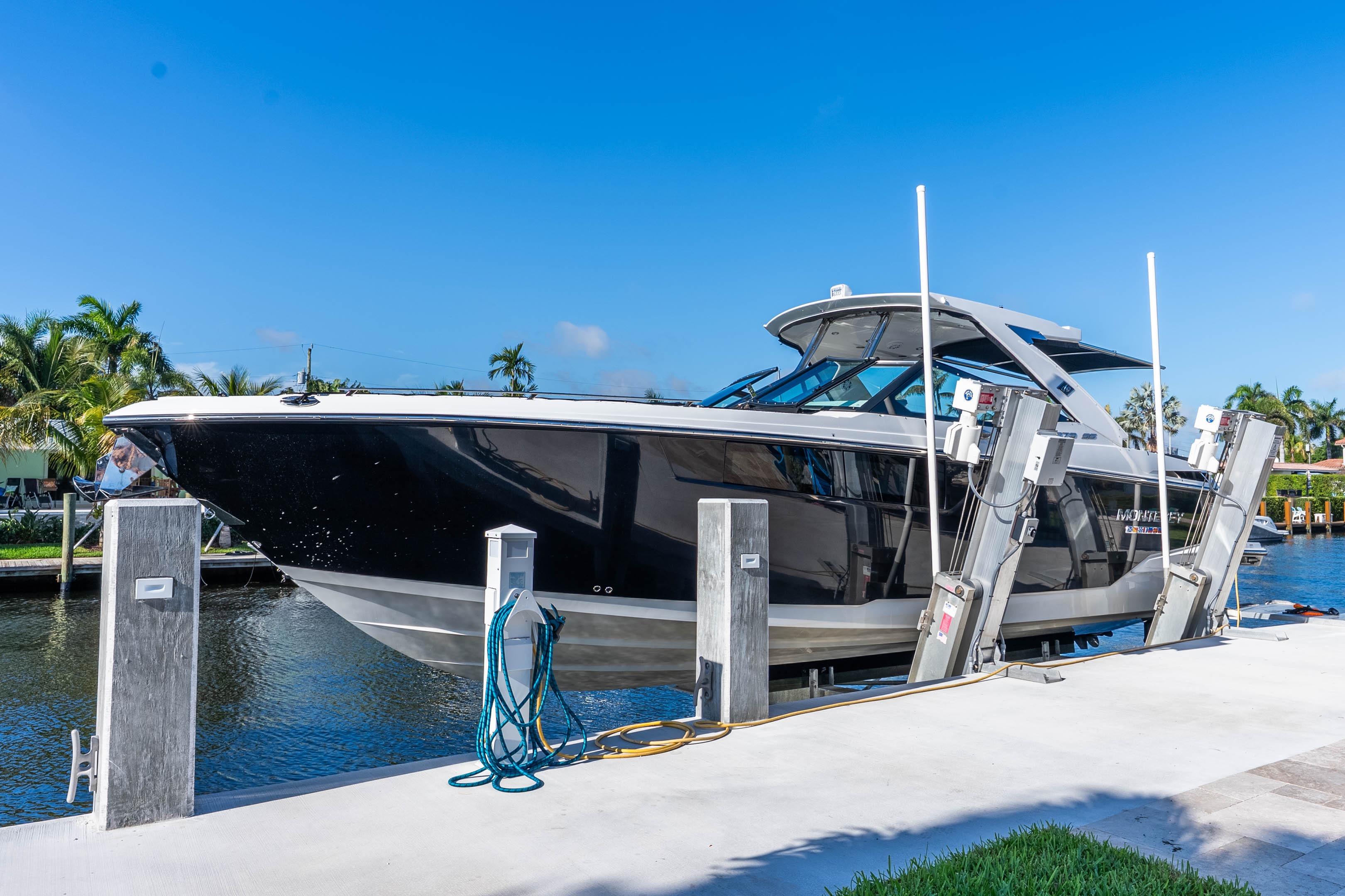 2022 Monterey 378SS Super Sport boat docked by a canal under clear blue skies.