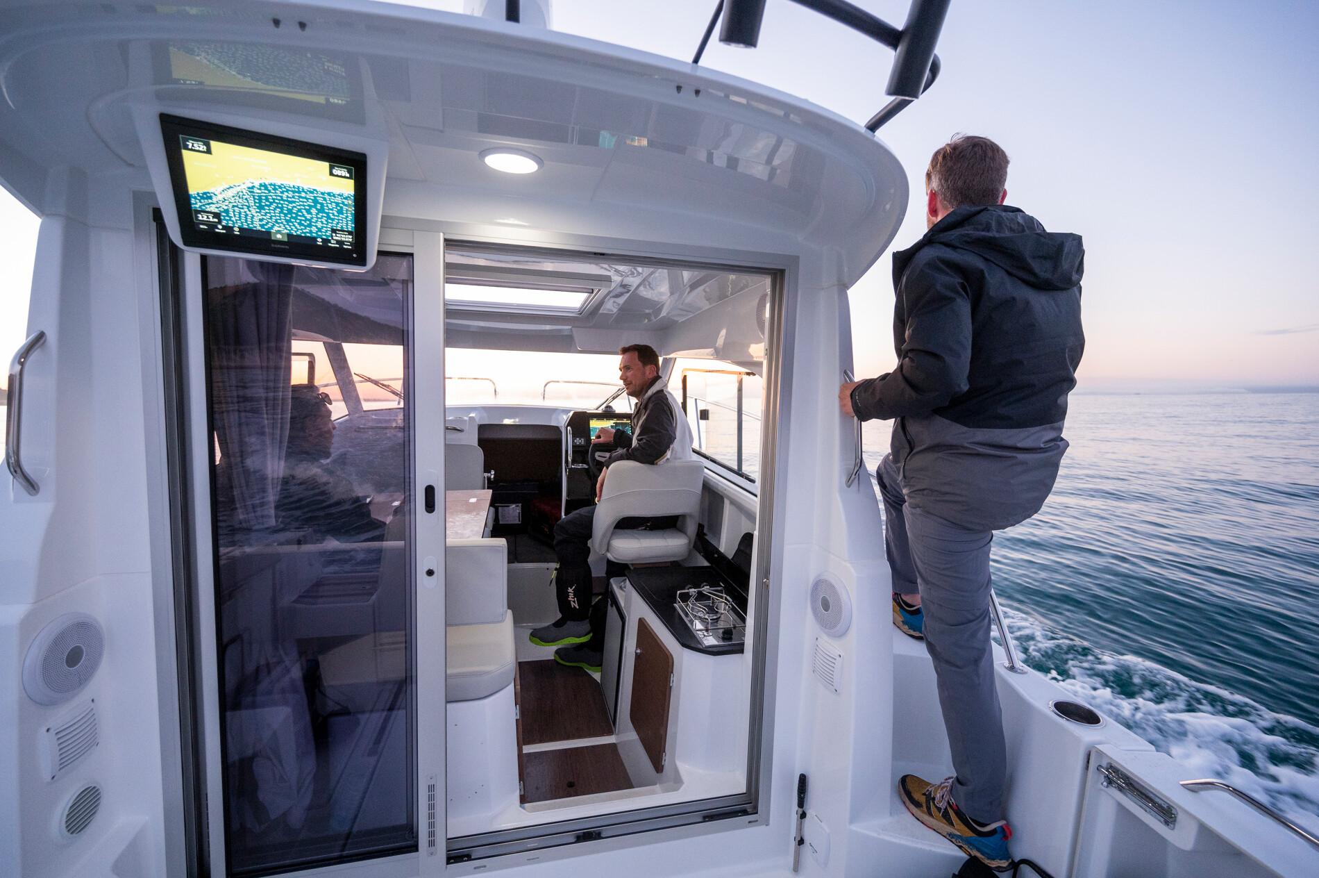 2024 Beneteau Antares 8 Fishing boat interior with two people at sea.