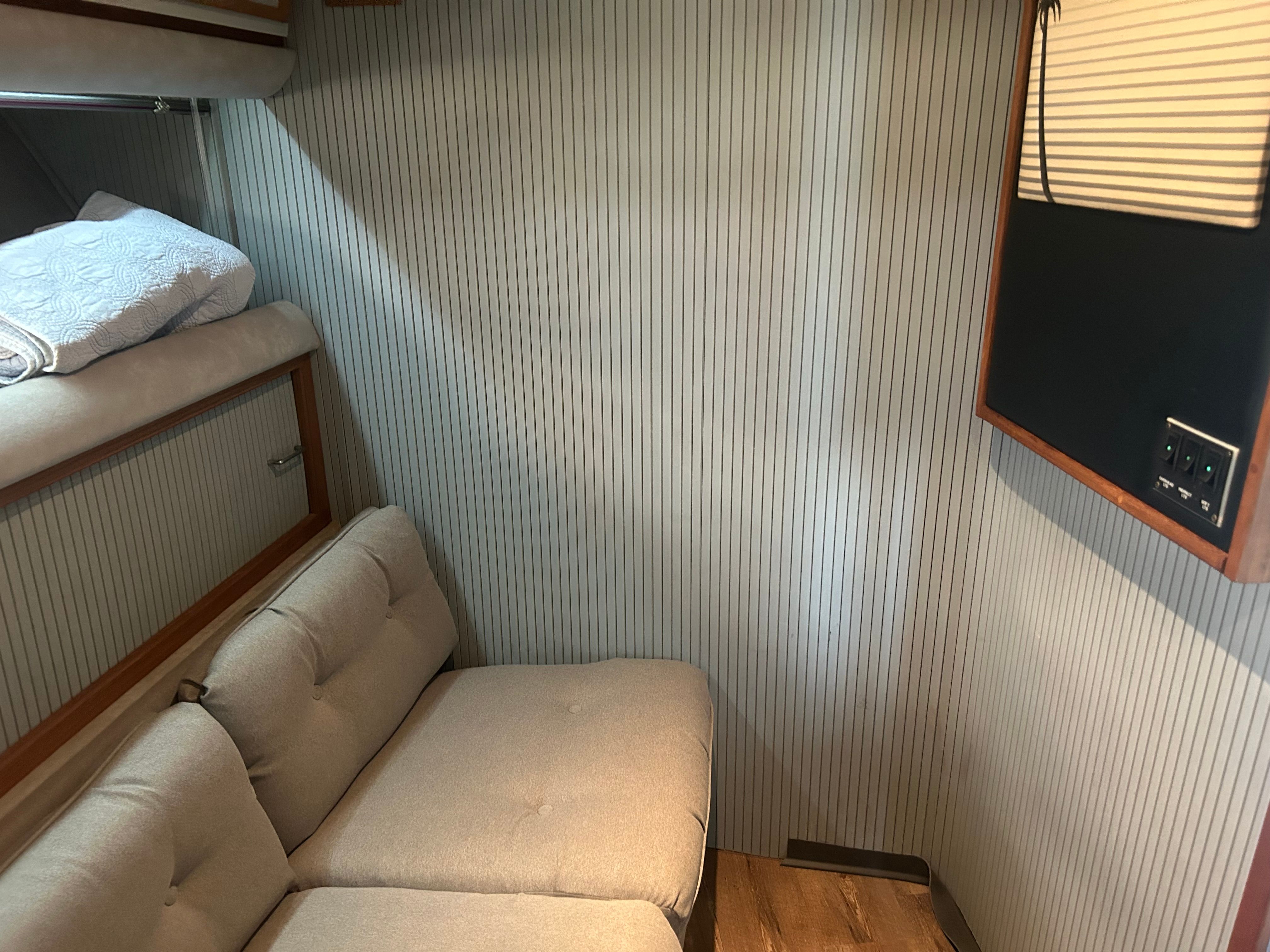 Interior of a yacht with beige sofa and wooden floor.