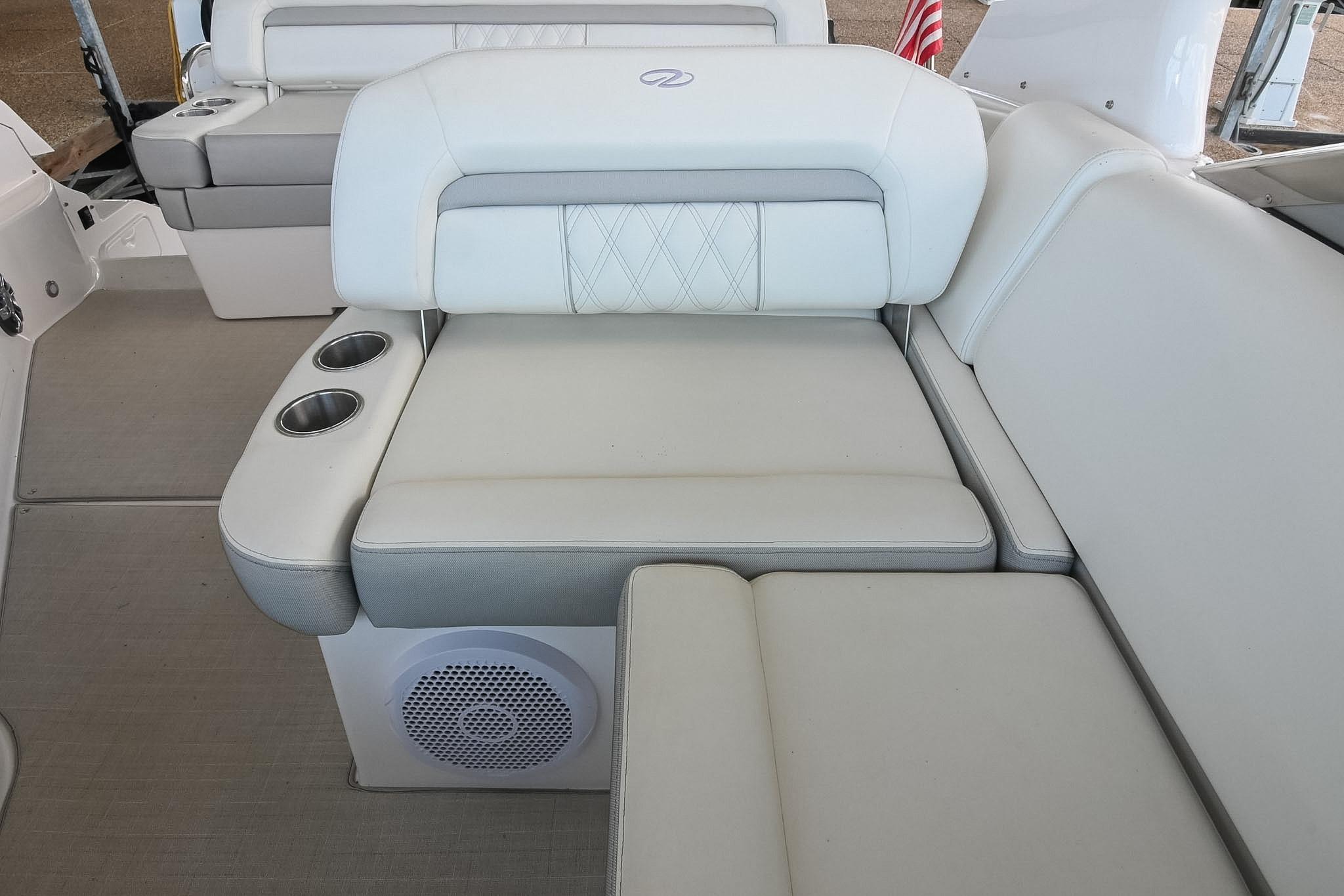 Luxurious seating on 2021 Regal 33 Express boat with cup holders and speaker.