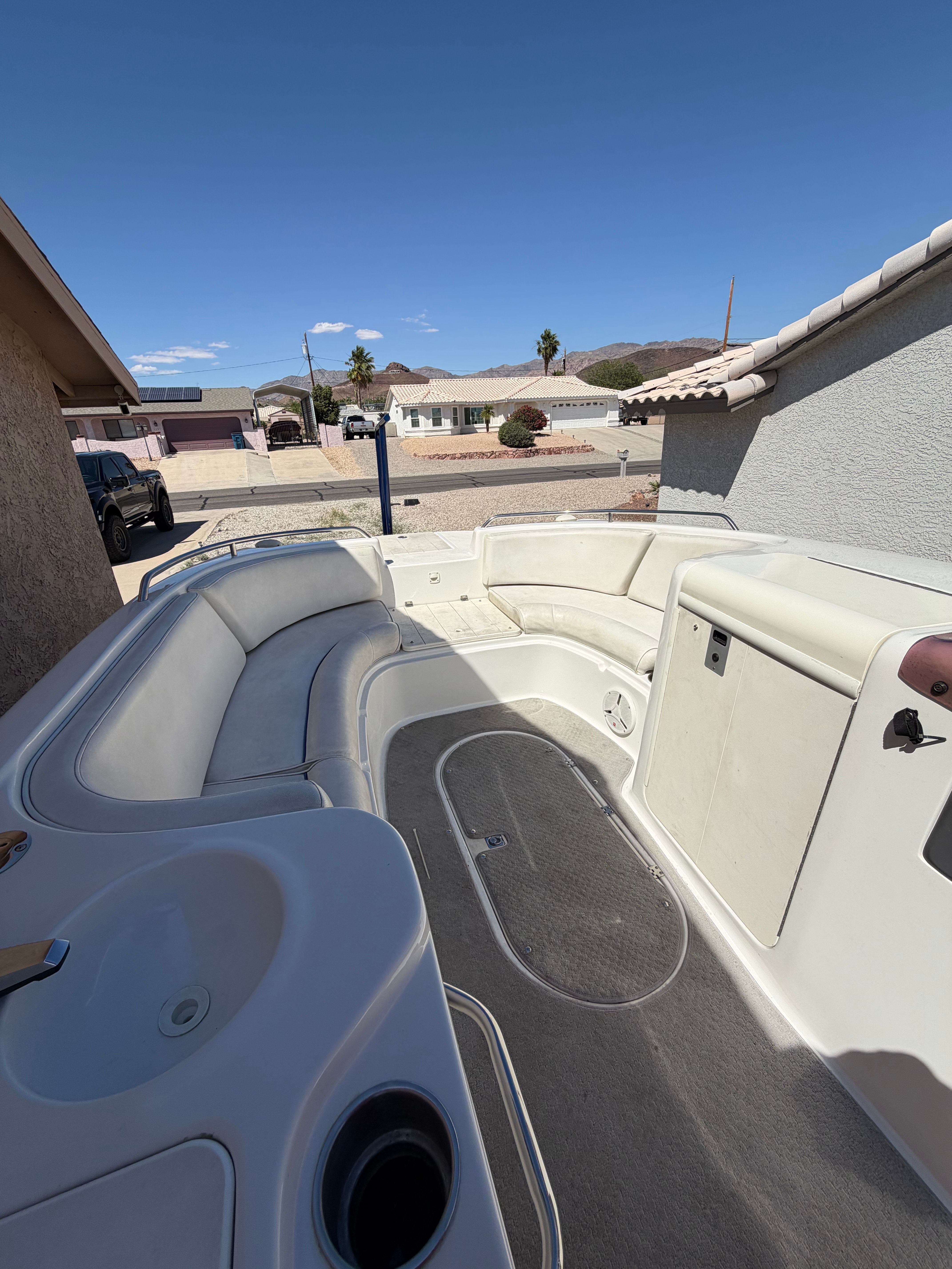A 2008 Ebbtide 2100 SS Fun Cruiser O/B is parked on a trailer in a driveway.