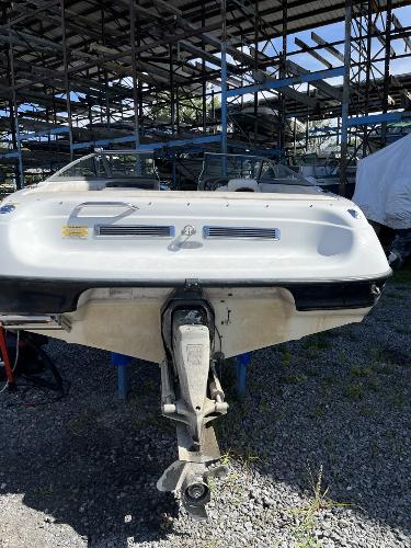 2005 Crownline 180 BR boat in storage, rear view with outboard motor.