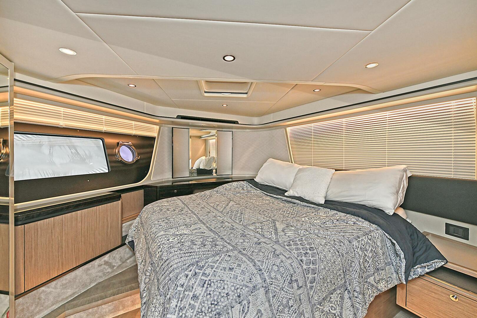 Luxurious bedroom interior of 2022 Absolute 62 Fly yacht with modern design and cozy bedding.