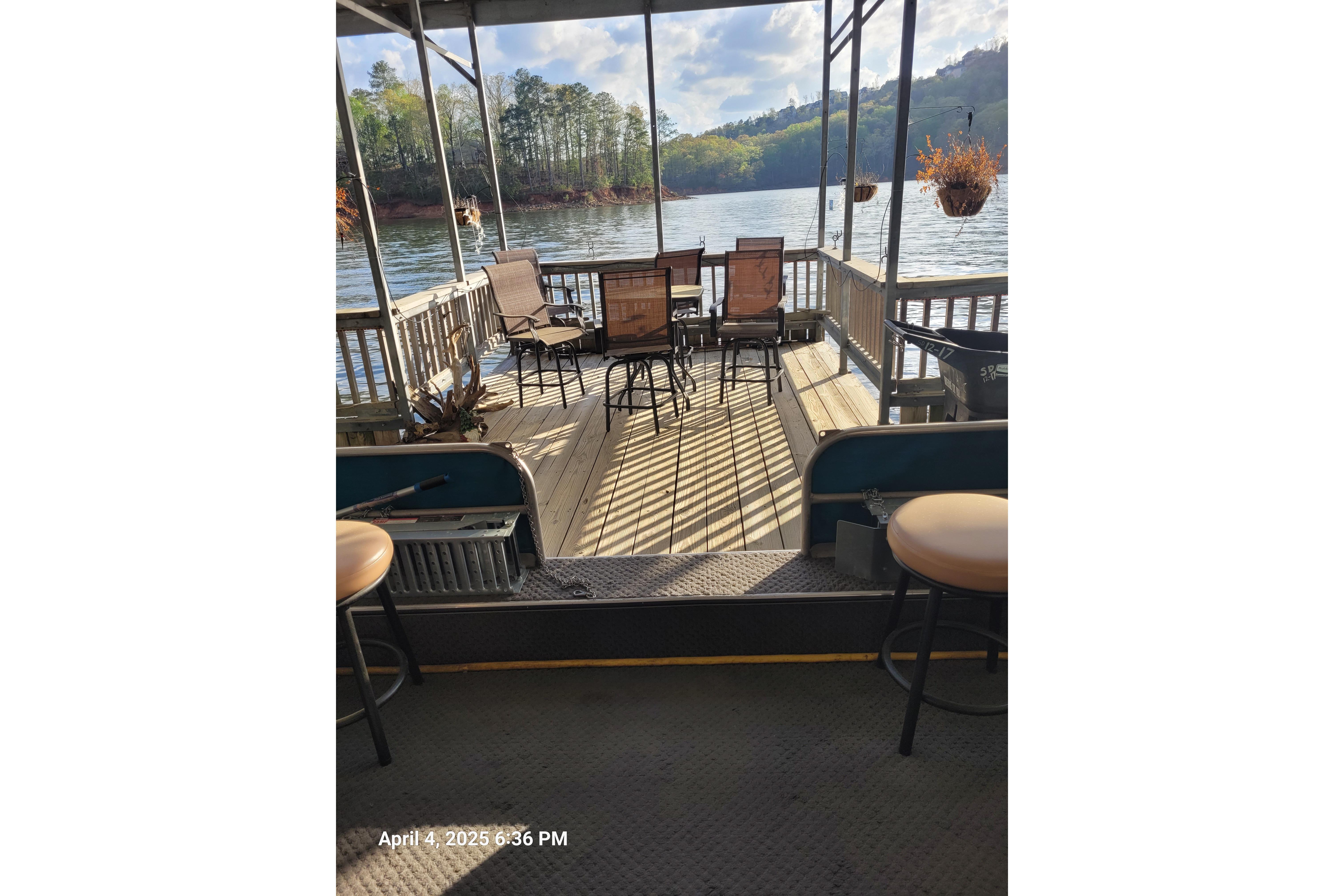 Houseboat deck with chairs overlooking a scenic lake, Sumerset 16 x 70, 1990 model.