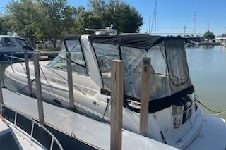 2000 Rinker Fiesta Vee 310 boat docked at marina with canopy.