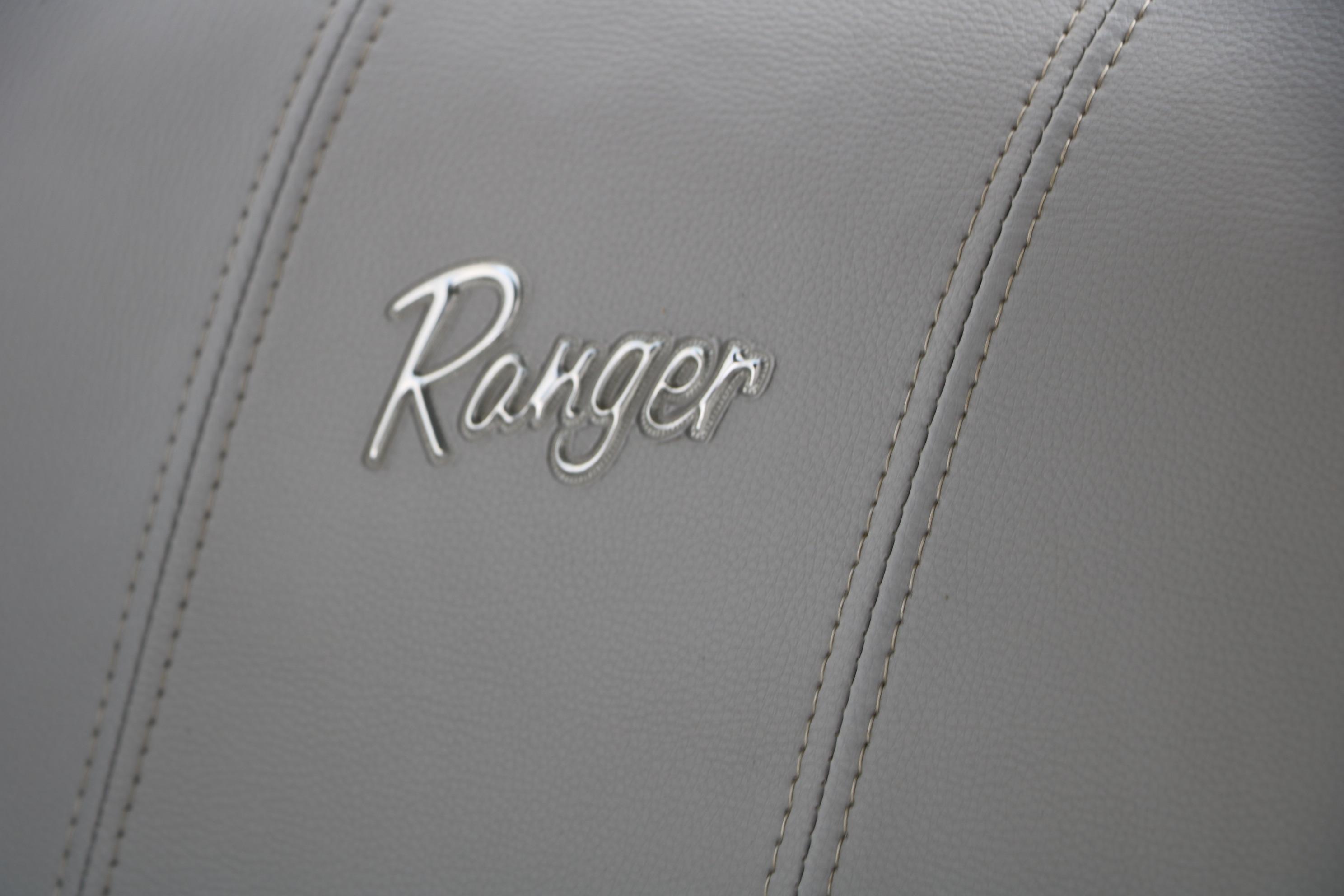 Close-up of 2021 Ranger 223FC logo on gray leather upholstery.