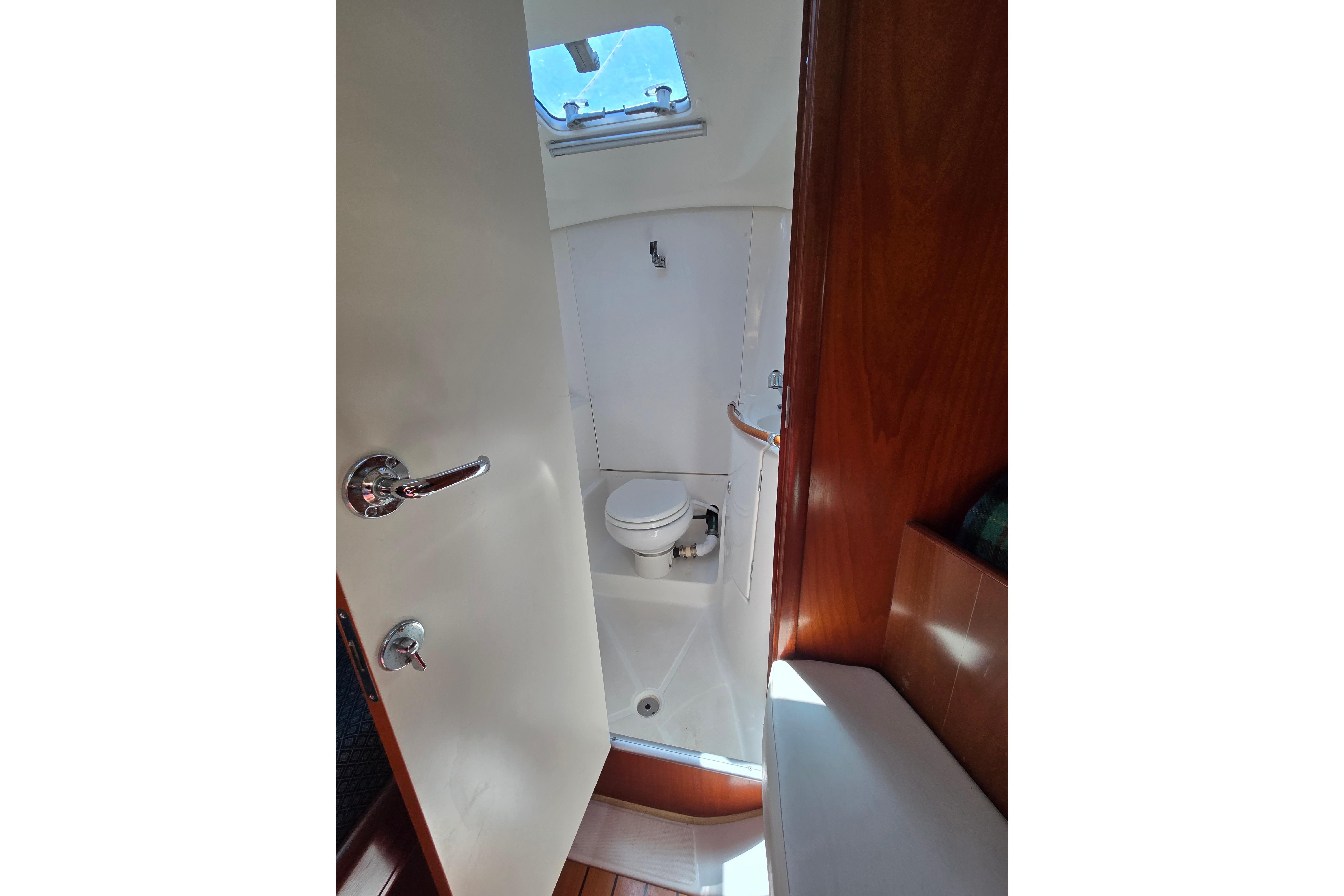 Interior view of a 2003 Beneteau 393 yacht bathroom with toilet and shower.