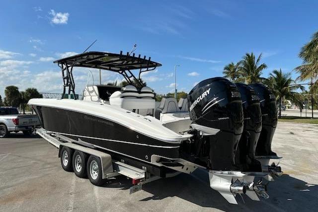 2009 Midnight Express 34 Open boat with triple Mercury engines on a trailer.