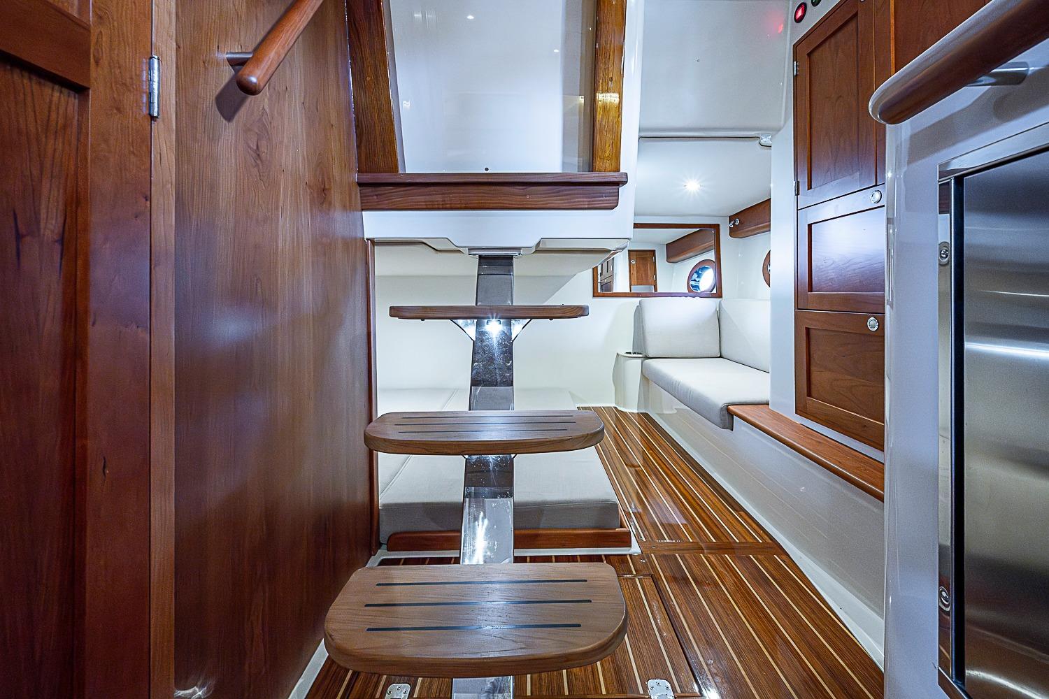 Interior of 2023 Hinckley Sport Boat 40 X with wooden stairs and seating area.
