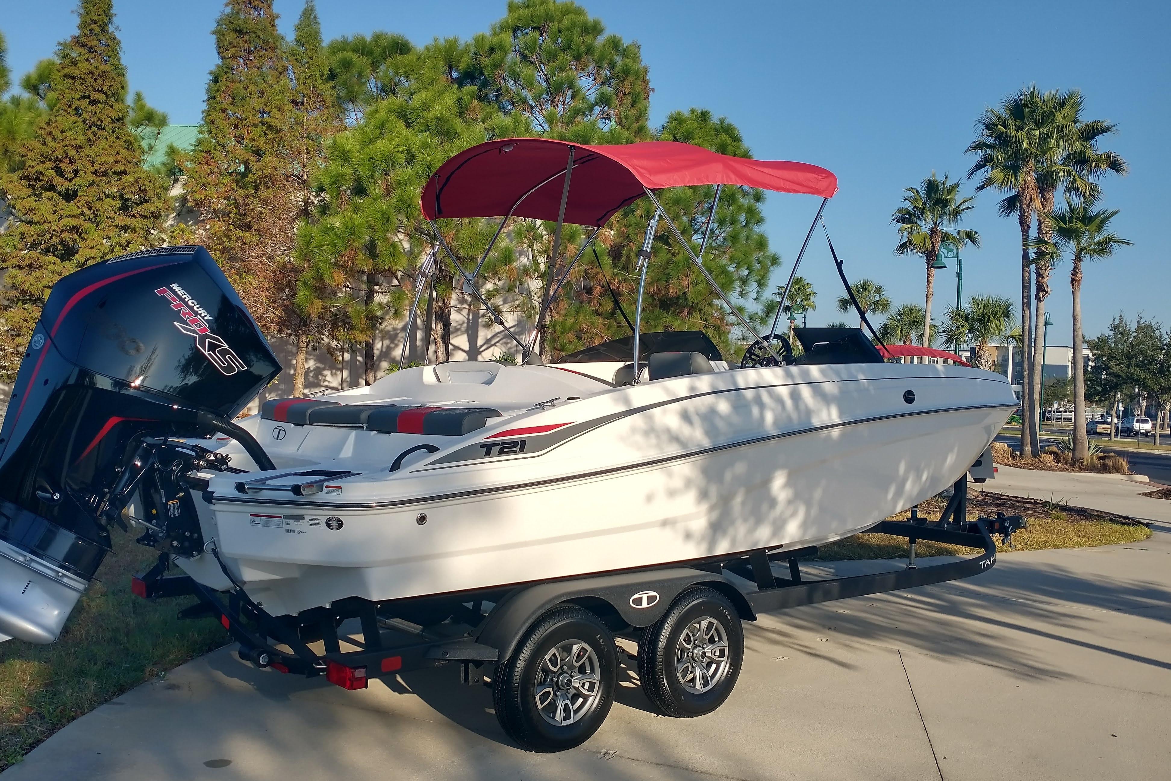 2026 Tahoe T21 boat with red canopy on trailer, parked outdoors.