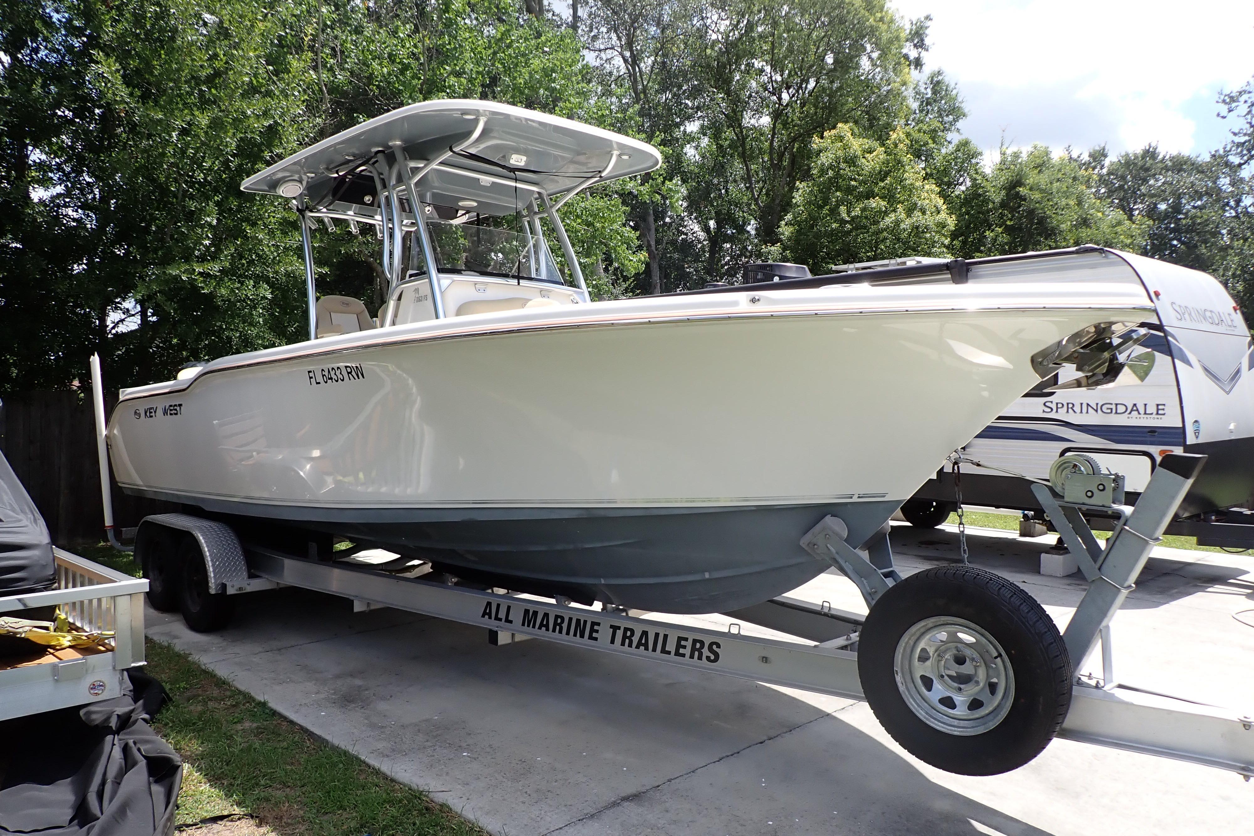 2019 Key West 263 FS boat on trailer, parked outdoors with trees in background.