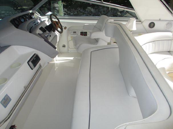 1994 Sea Ray 500 Sundancer interior with white seating and helm station.