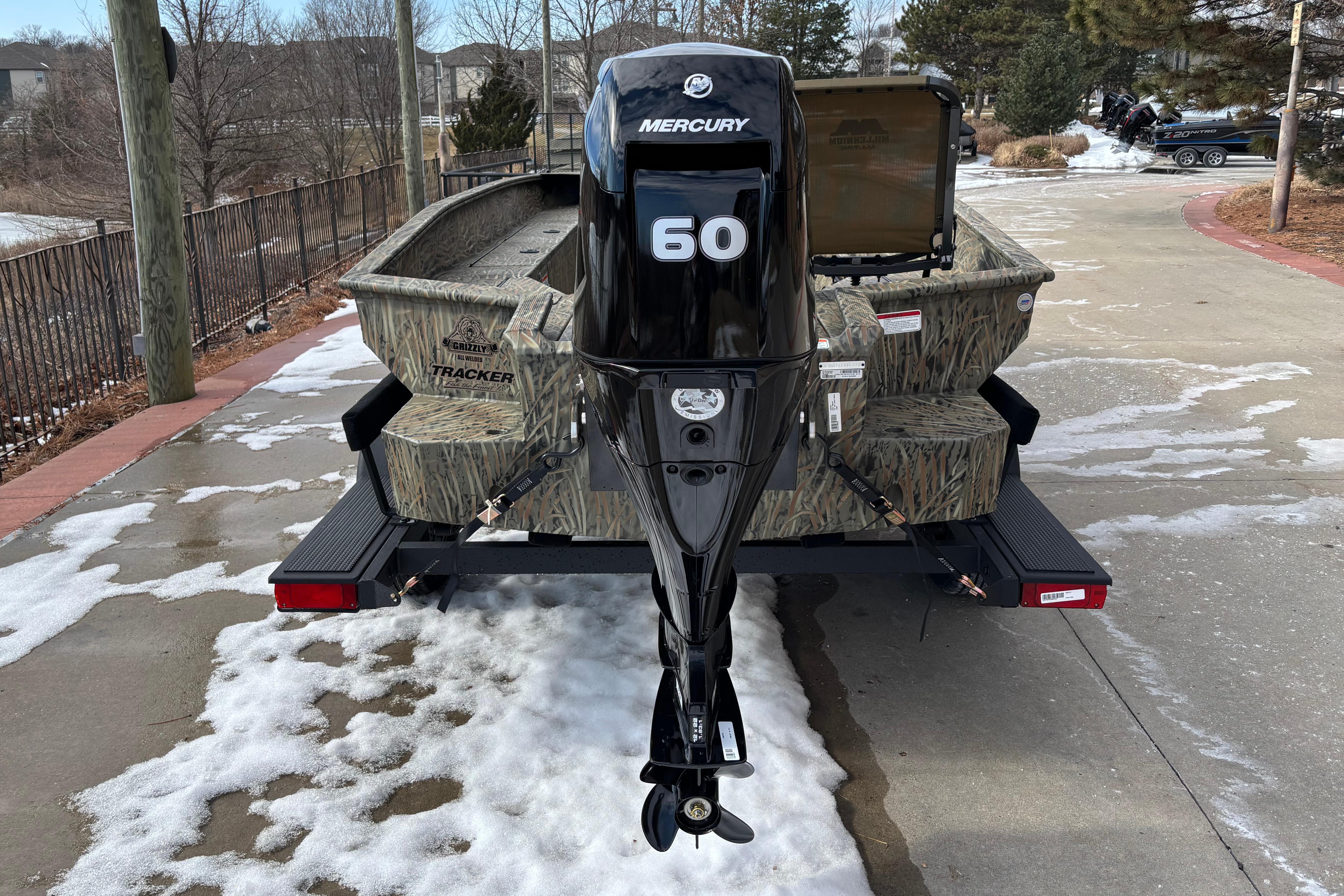 2026 Tracker Grizzly 1756 T Marsh boat with Mercury 60 engine on snowy driveway.