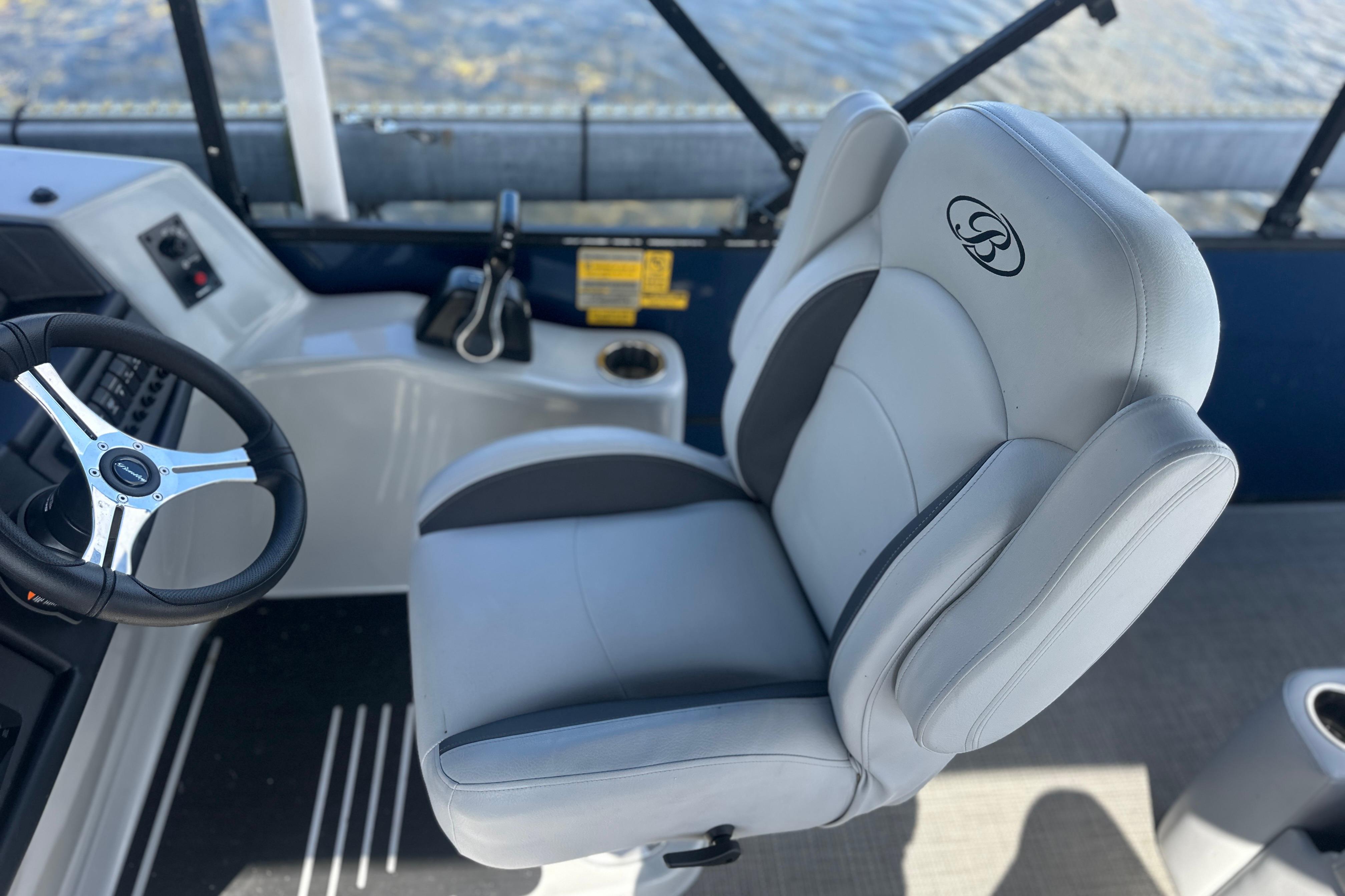 Captain's chair and steering wheel of 2023 Bentley Pontoons Legacy 243 Swingback boat.