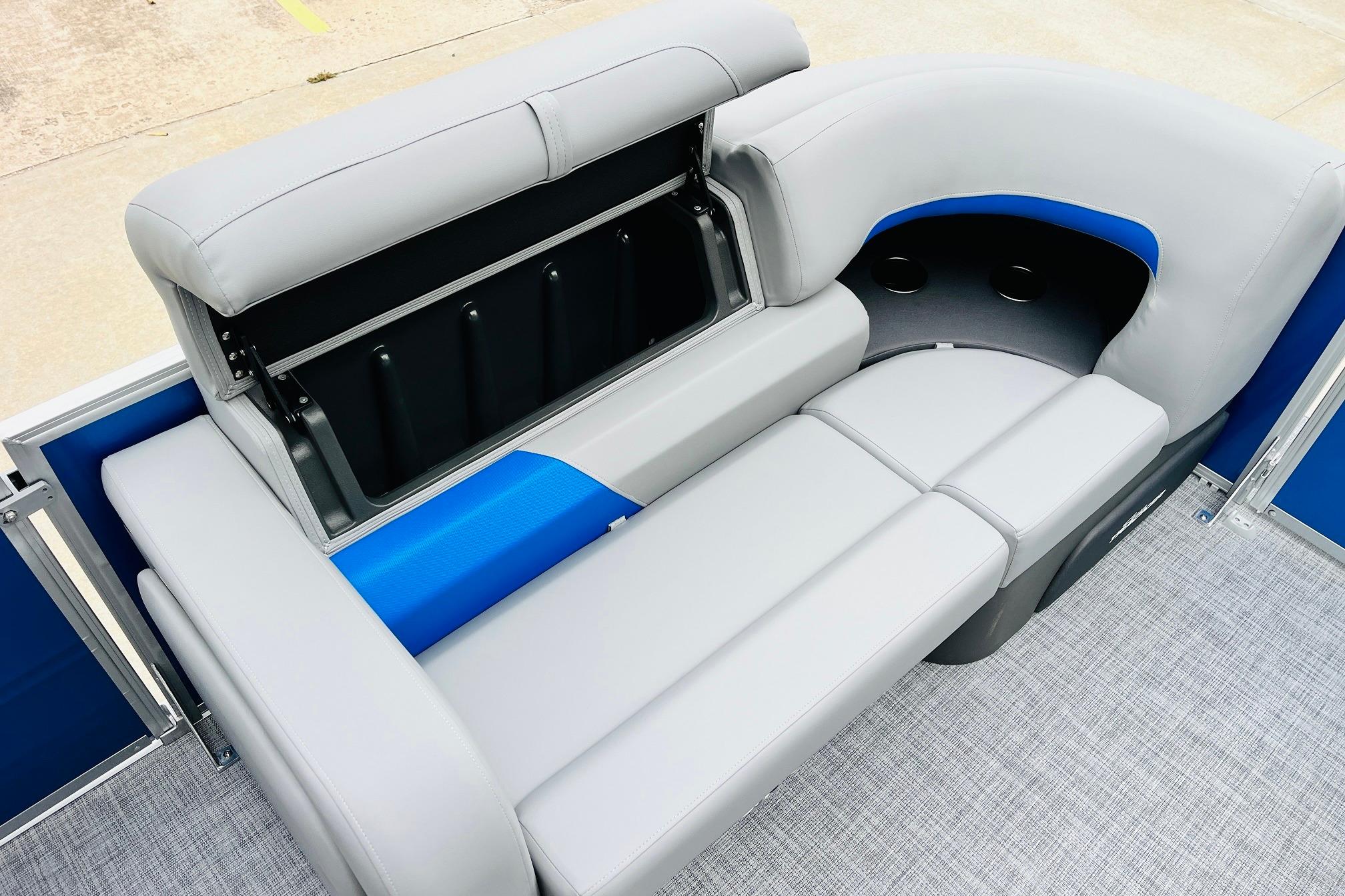 2026 Sun Tracker Party Barge 22 RF DLX seating with storage compartment, gray and blue upholstery.