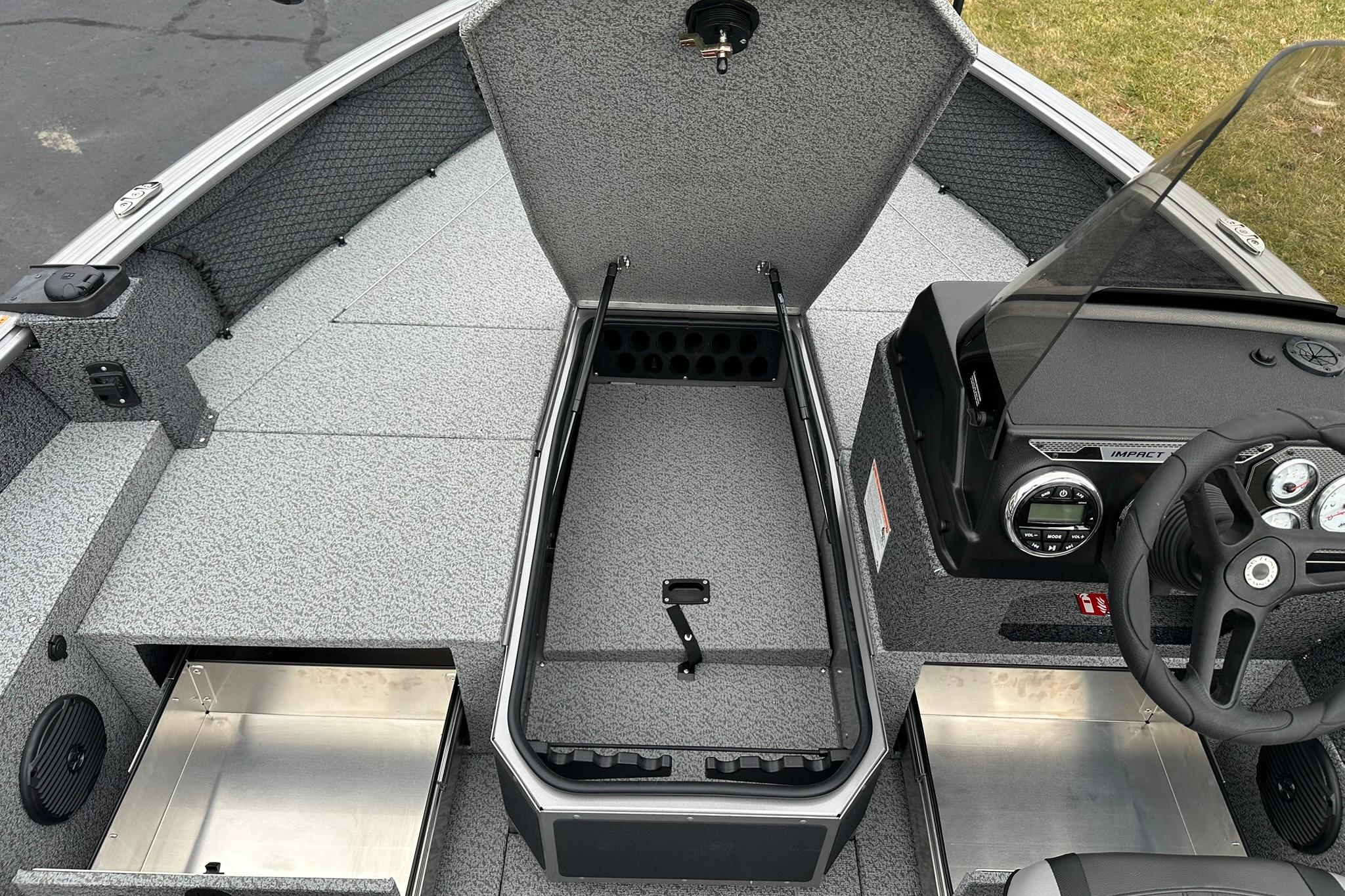 2026 Lund 1875 Impact XS SS boat interior with open storage compartments and steering console.