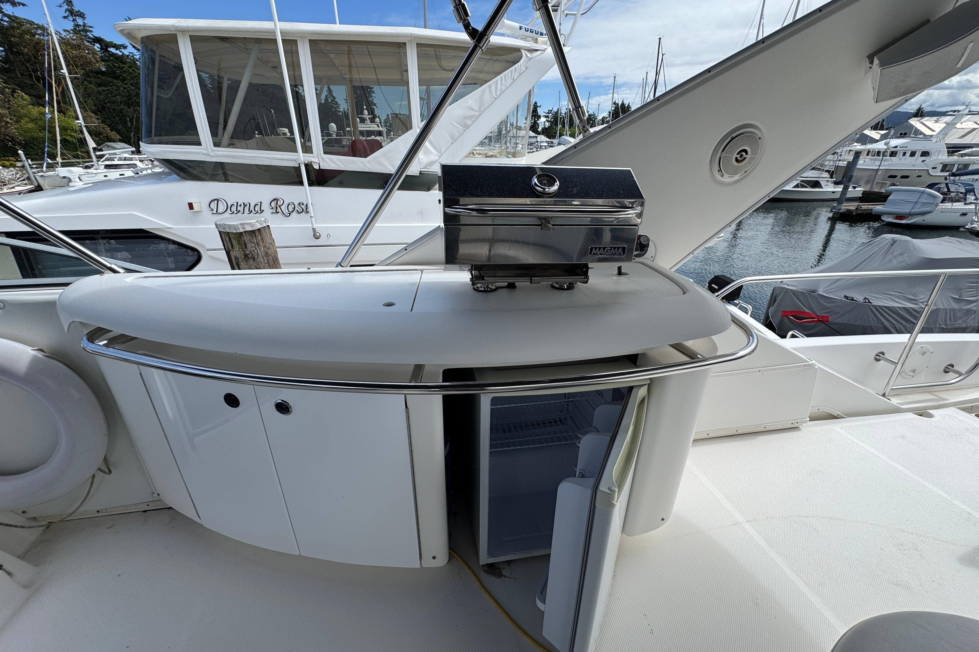 1998 Bayliner 5788 Pilot House Motoryacht with outdoor grill and storage, docked at marina.