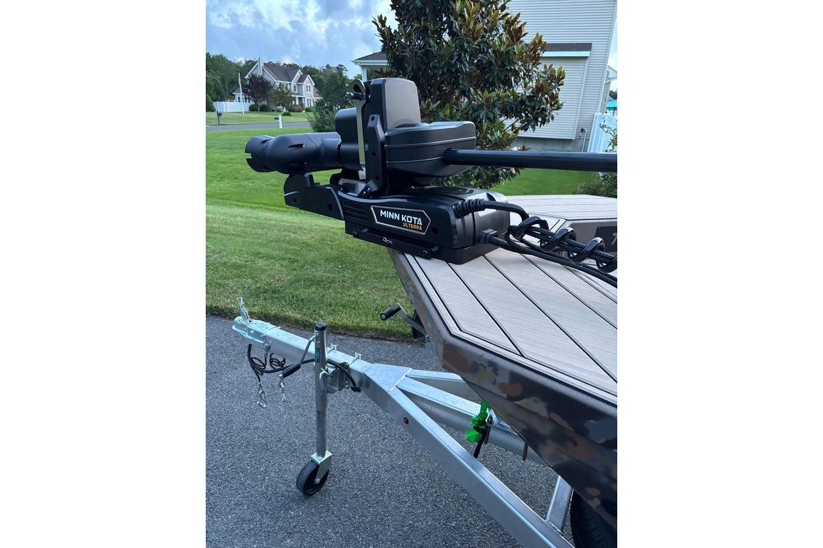 Boat trailer with Minn Kota motor, Thor Lake Hammer 2025 model, parked on a driveway.