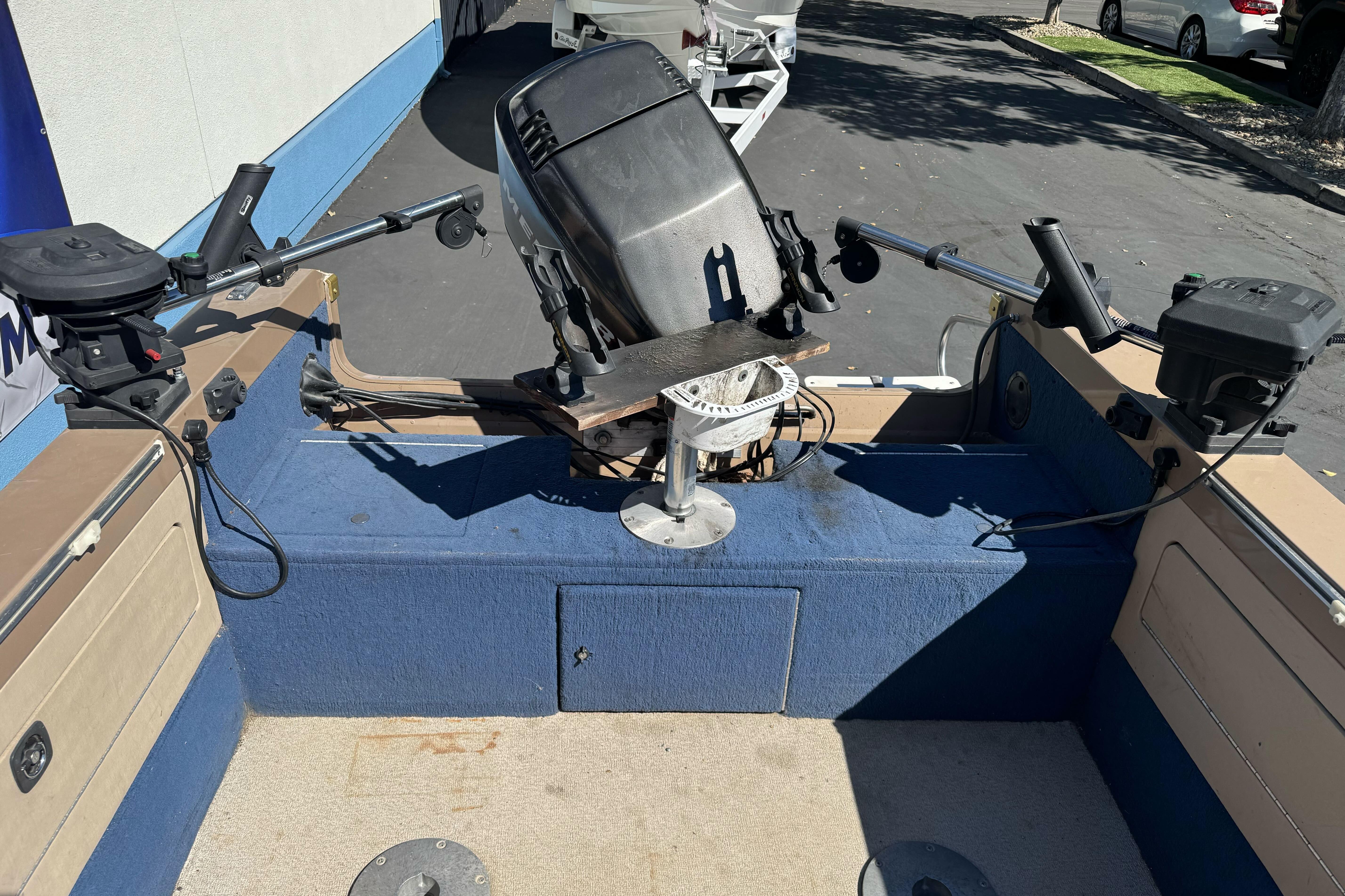 1998 Lund 1700 Pro Sport boat interior with motor and fishing rod holders.