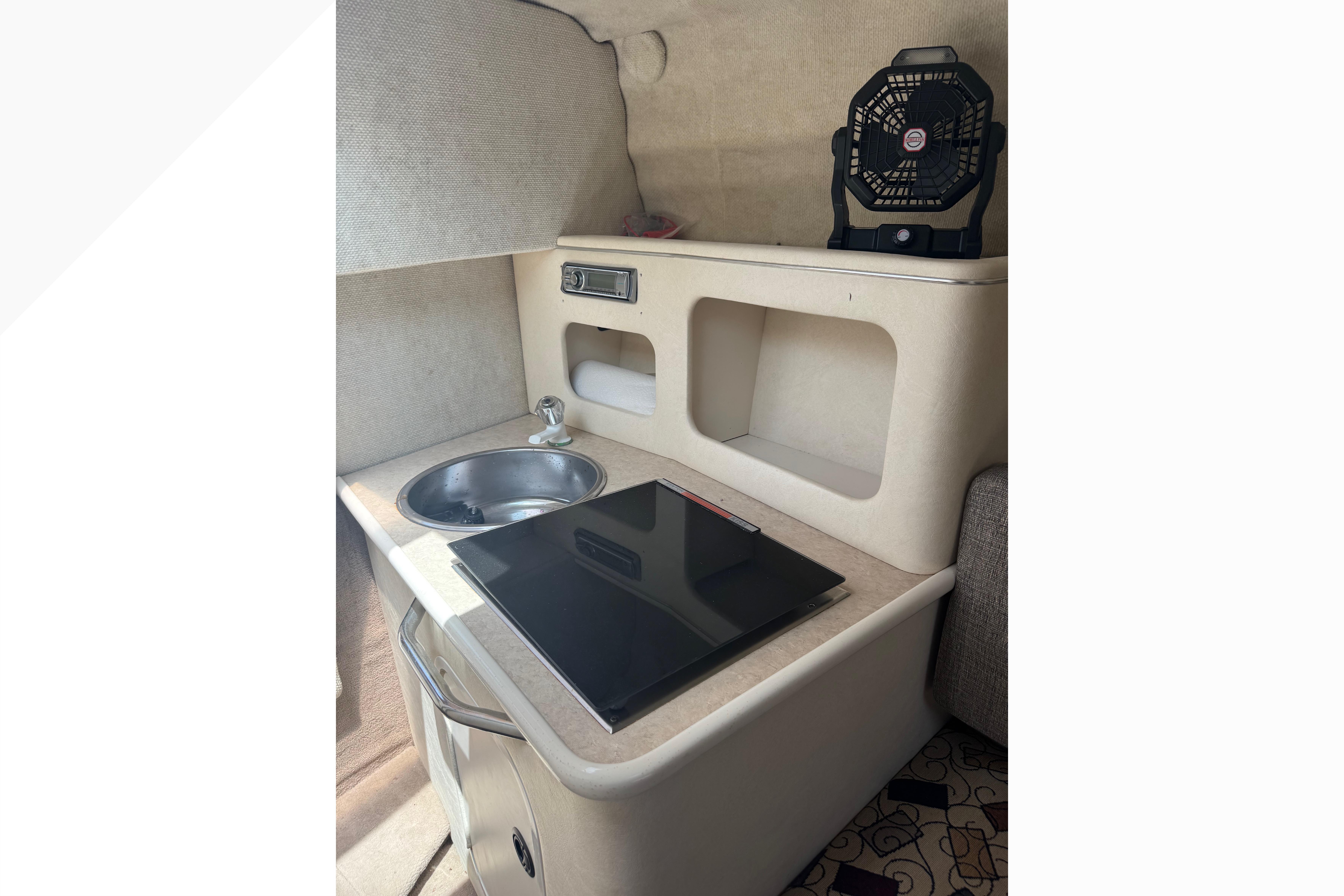 2001 Sea Ray 245 Weekender cabin interior with sink and fan.