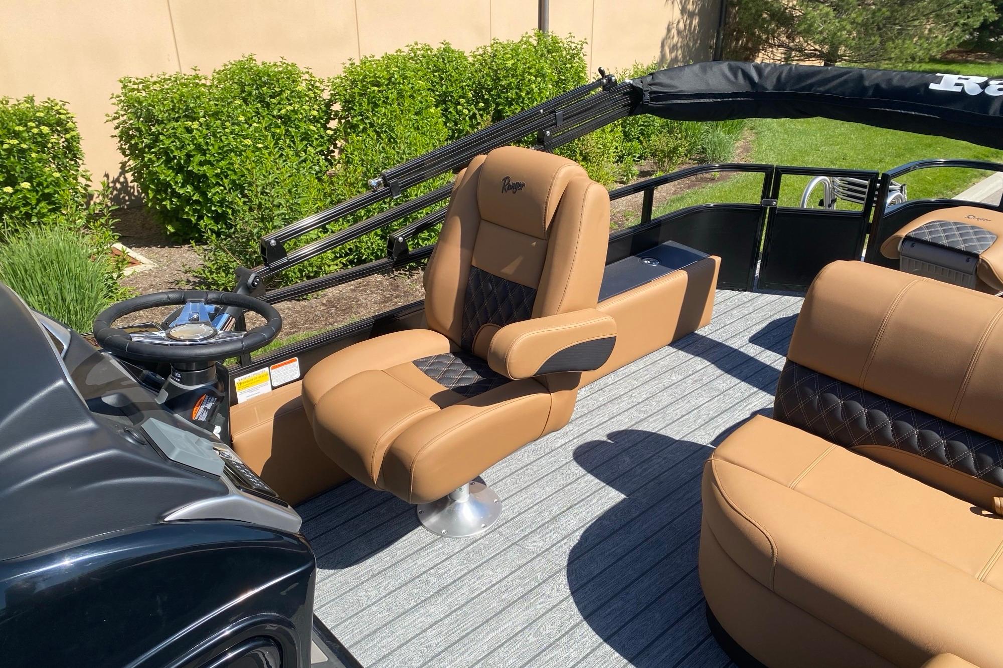 2026 Ranger 223F boat interior with tan seating and steering wheel, outdoors.