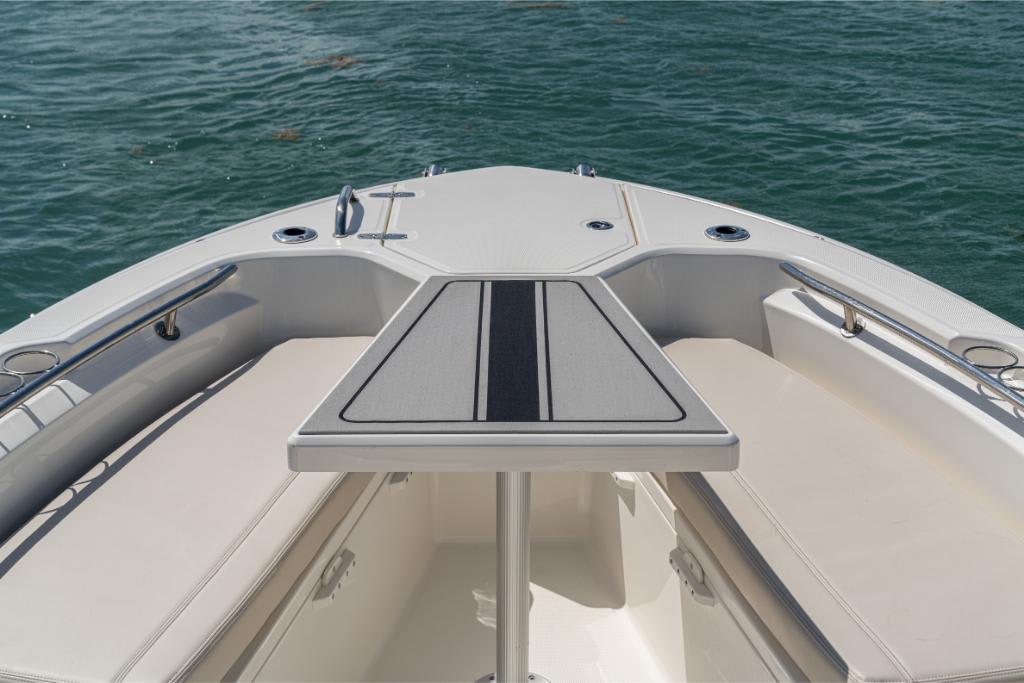 Bow seating area of 2024 Boston Whaler 280 Dauntless with table on calm water.