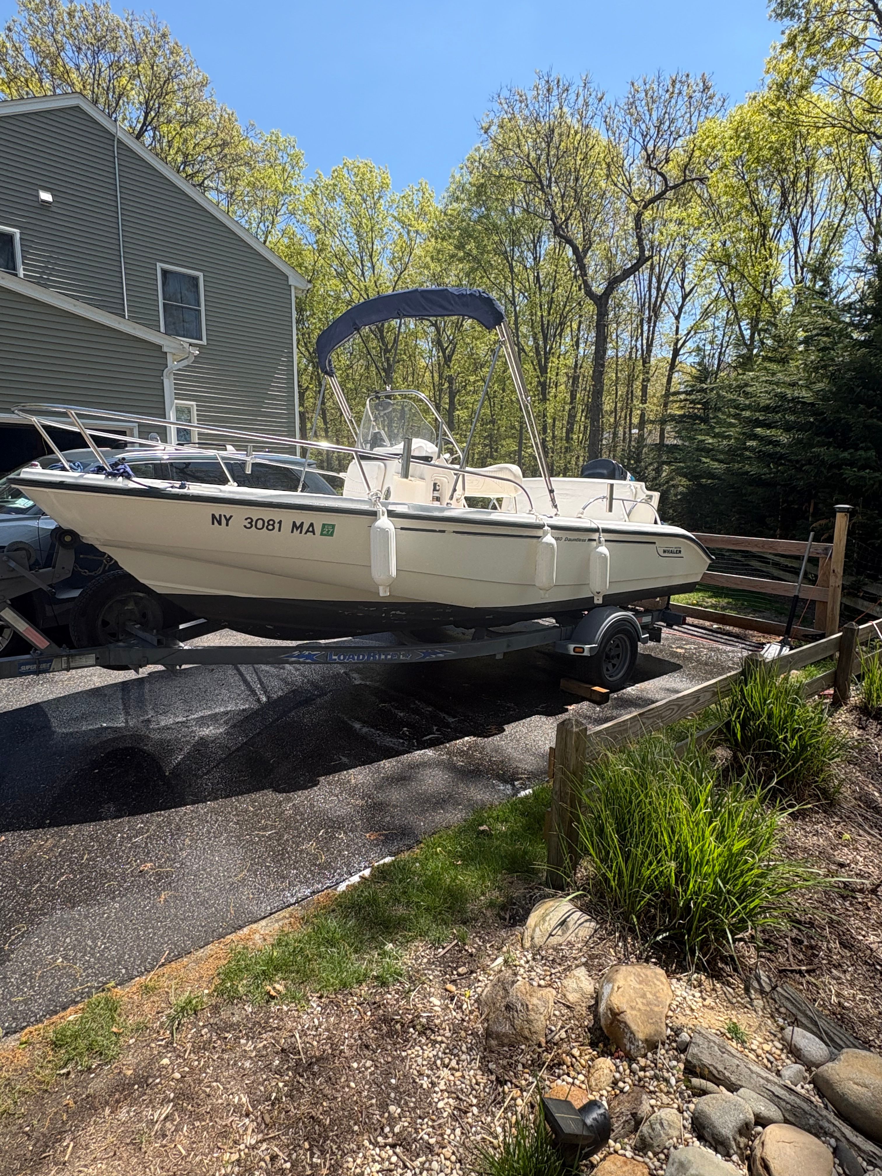 2004 Boston Whaler 180 Dauntless on trailer in driveway.
