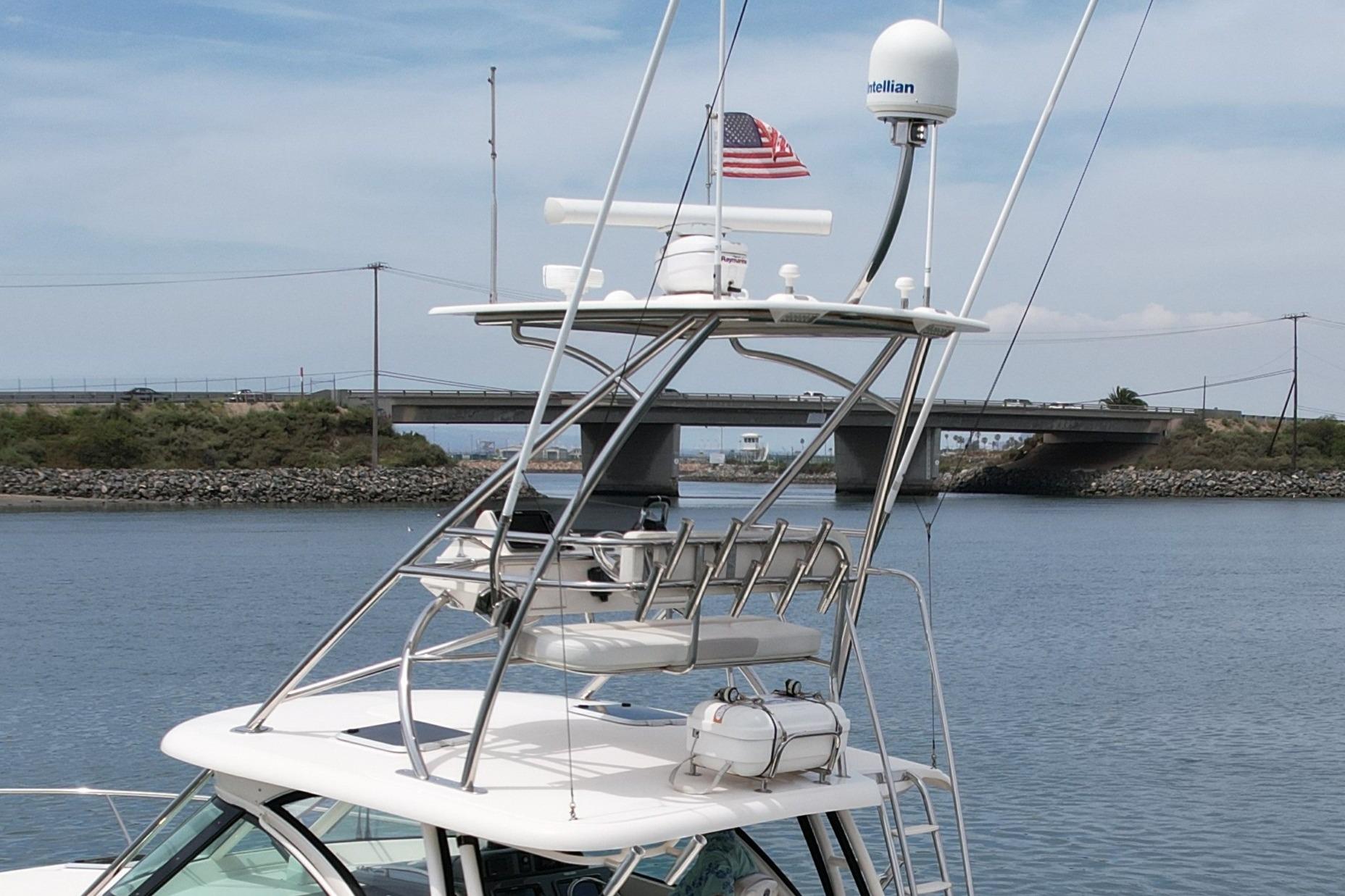 2012 Pursuit OS 345 Offshore boat with radar, American flag, and bridge in background.