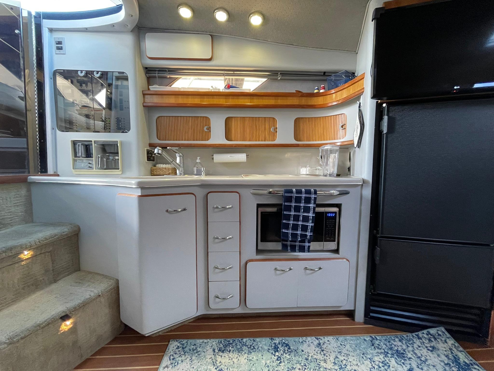 1989 Sea Ray 420 yacht interior kitchen with modern appliances and wooden accents.