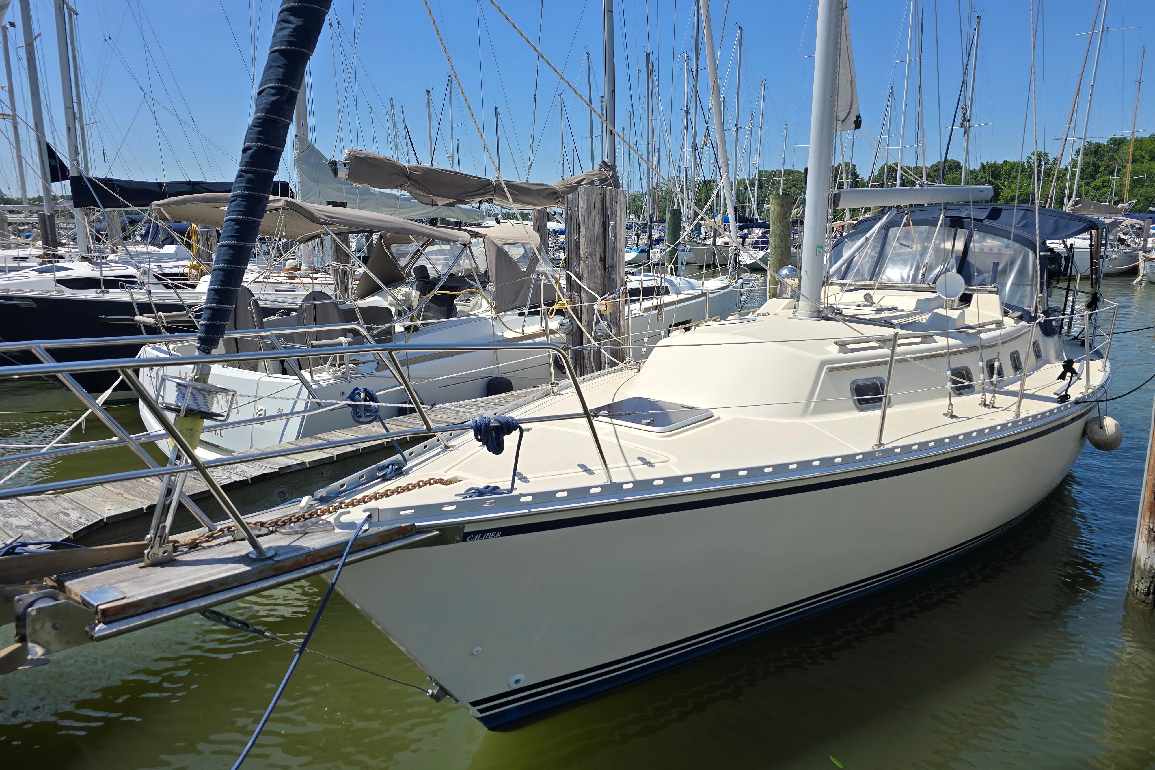 1993 Caliber 35 sailboat docked in a marina, surrounded by other boats.