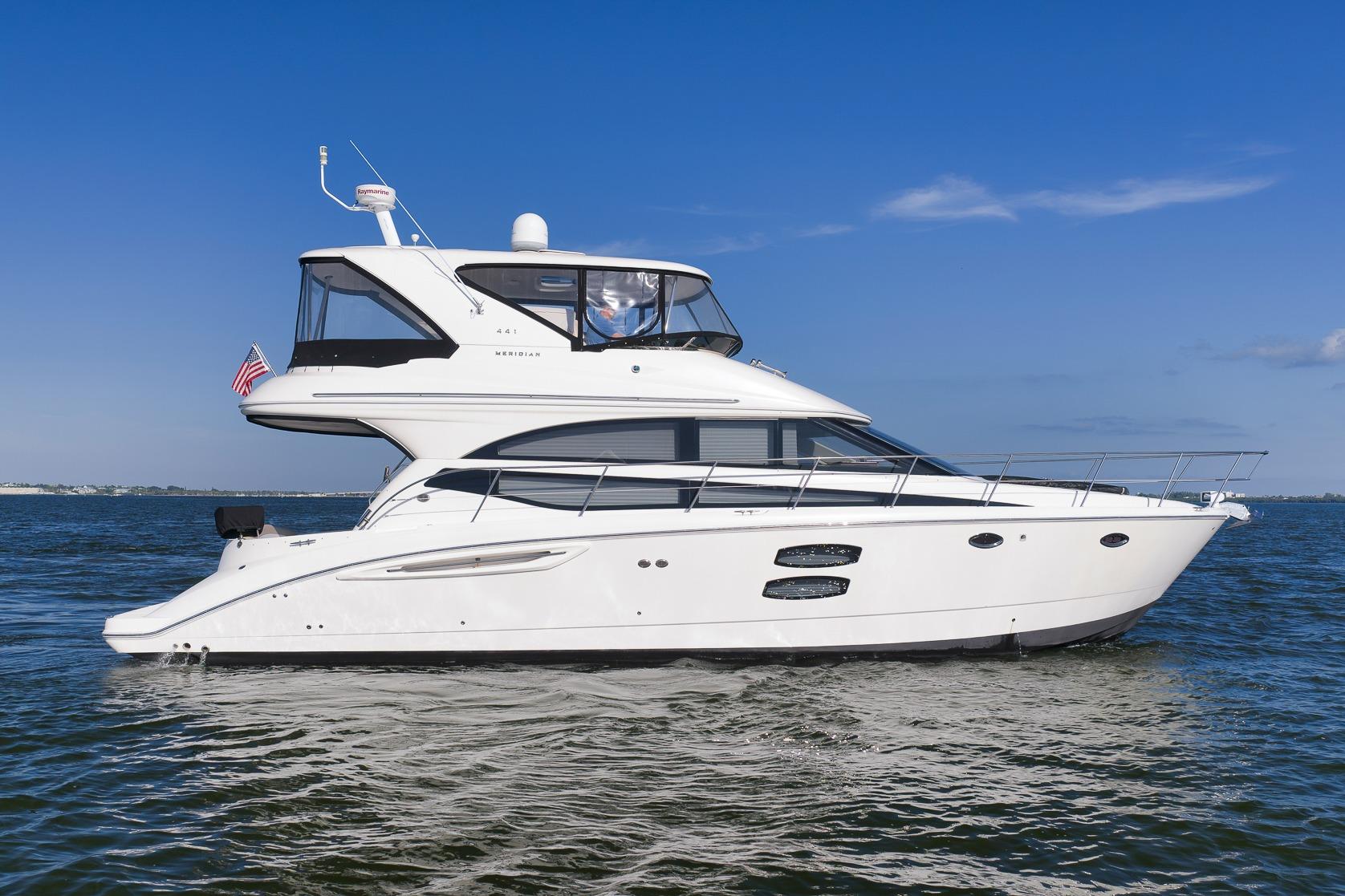 2012 Meridian 441 Sedan yacht cruising on open water under clear blue skies.