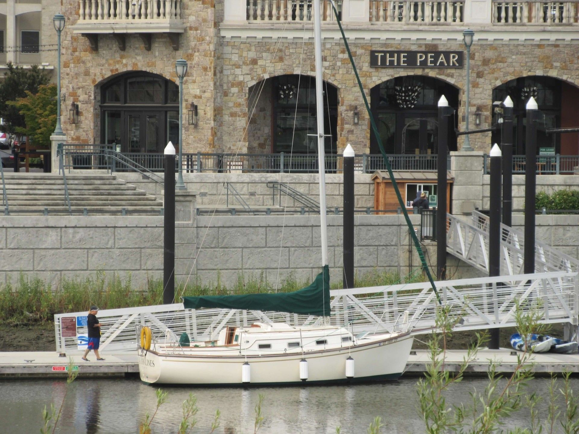 1985 Island Packet IP-27 sailboat docked in front of building.